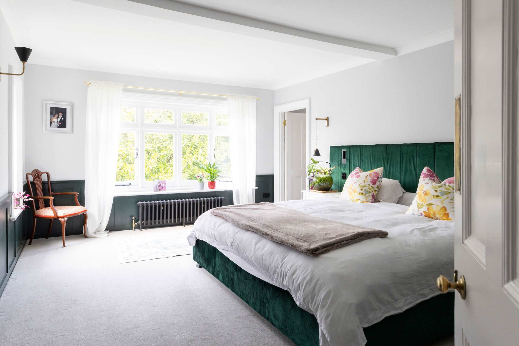 Welcome tio the elegant emperor suite featuring a plush green headboard and garden views