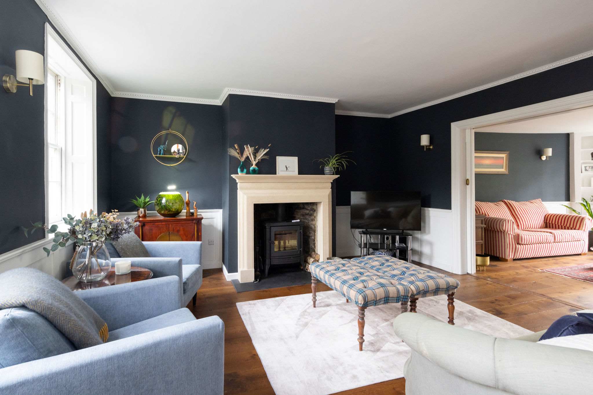 A refined sitting room with a statement log burner and deep blue walls