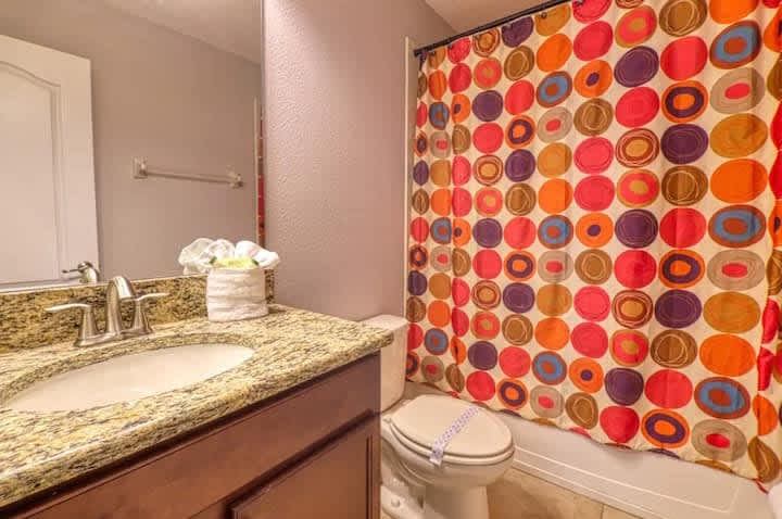 Bathroom w/ sink and vibrant tile accents adding a pop of color.