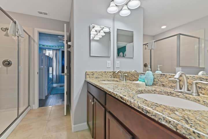 Clean bathroom w/ granite counter, sink, and glass-enclosed shower for a fresh, functional start to the day.