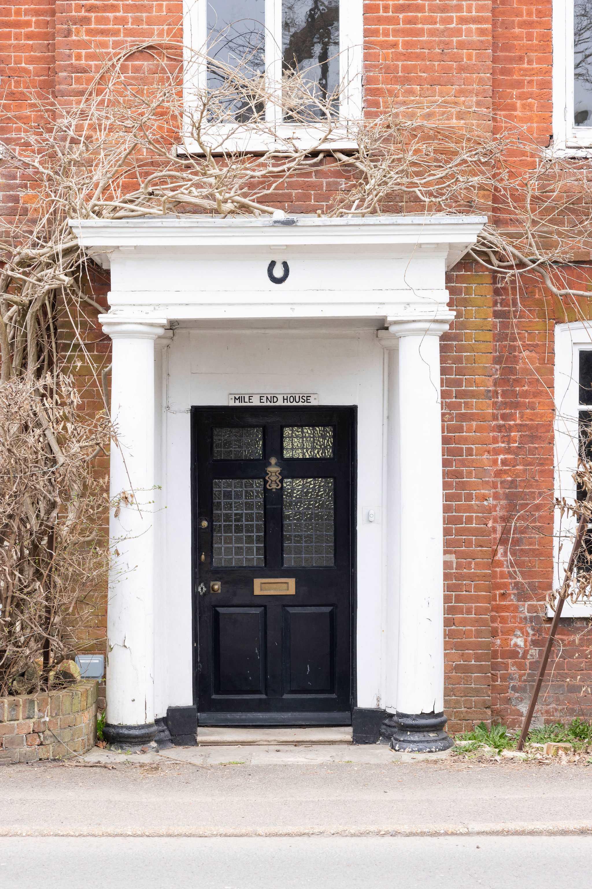 Grand entrance with classic red brick, white columns, and character by the bundle