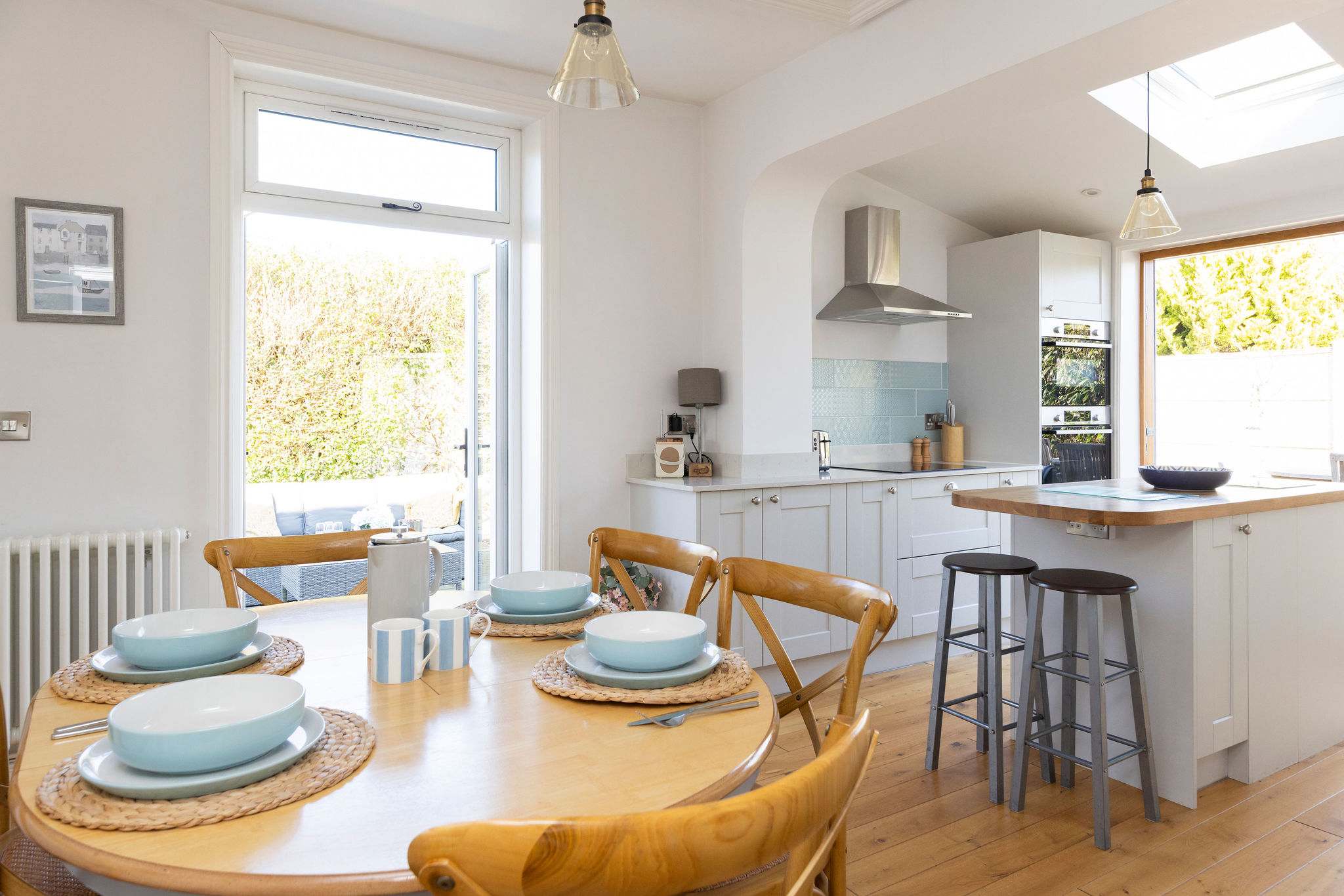 Enjoy family meals and gatherings in the bright and airy open-plan kitchen and dining area. This inviting space features a dining table with seating for six and seamless access to the outdoor patio.