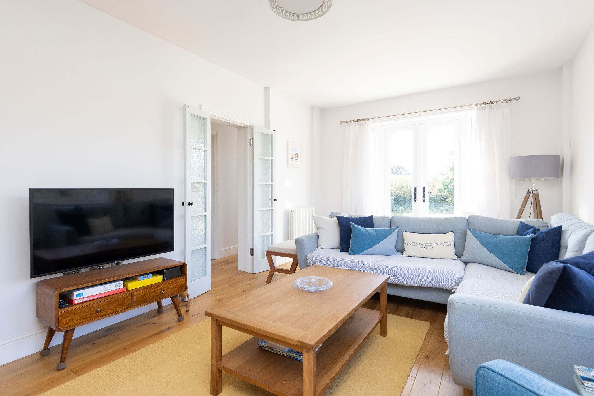 Relax in the cosy lounge of this seaside cottage, perfect for unwinding after a day at nearby East Wittering Beach.
