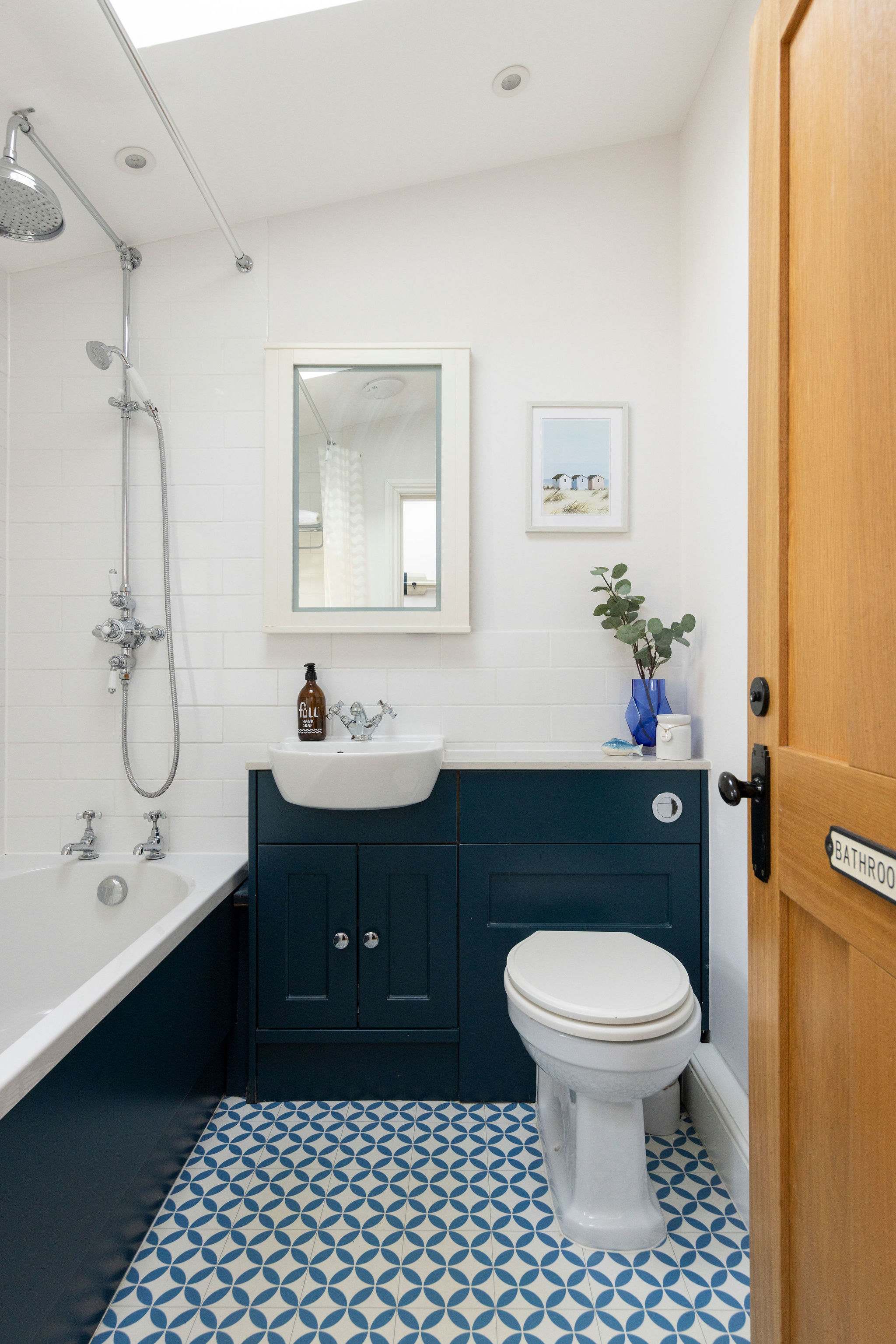 Stunning blue floor tiles paired with sleek black paneling bring a bold, sophisticated touch to this bathroom.