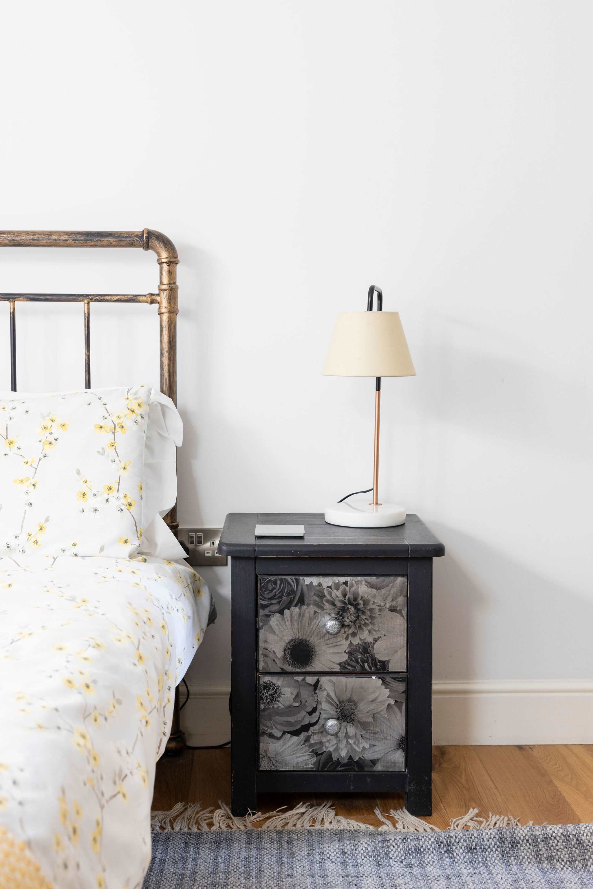 Comfortable bed with chic side table and lamp.