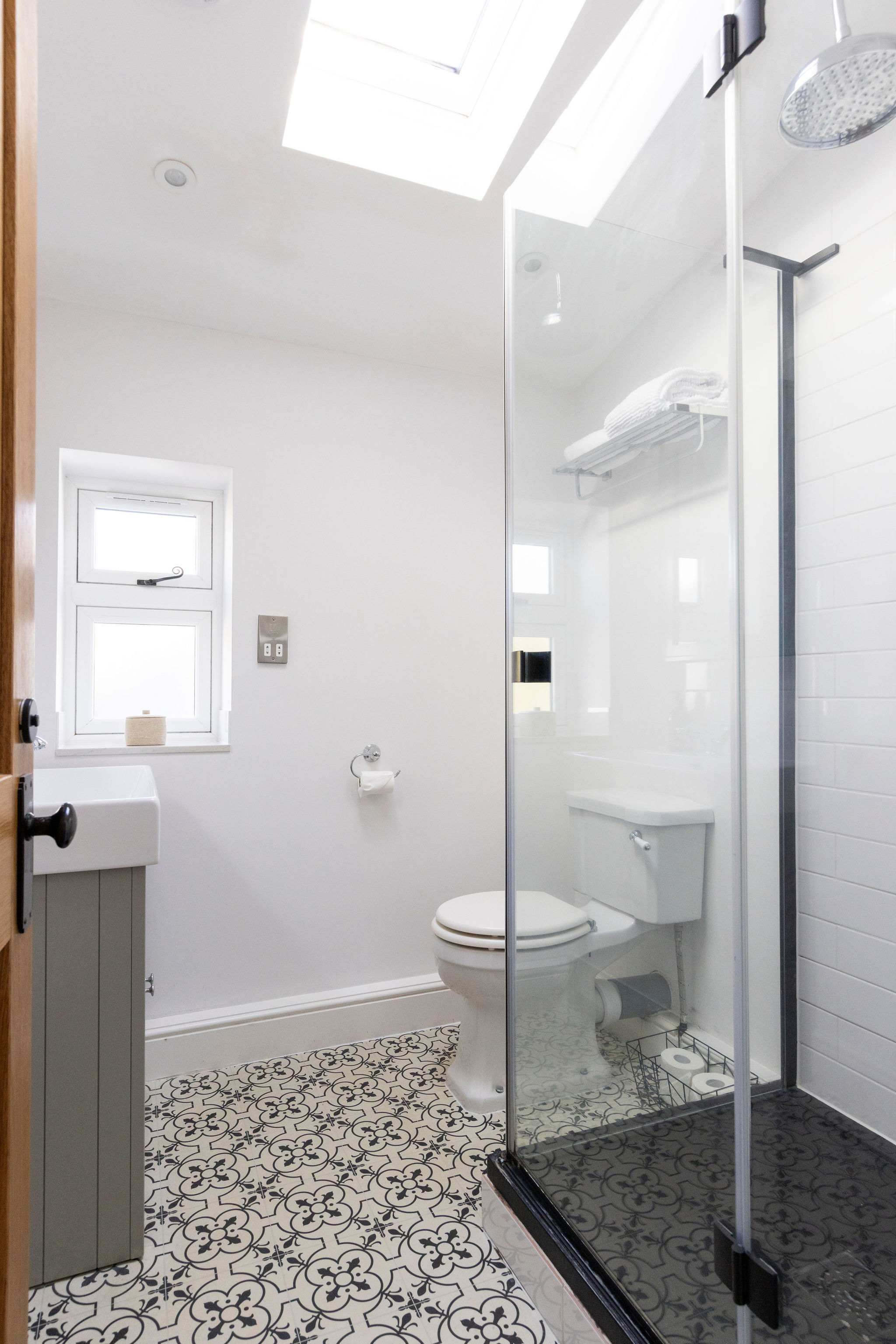 En-suite This bright and modern bathroom features a walk-in shower, toilet, and sink.