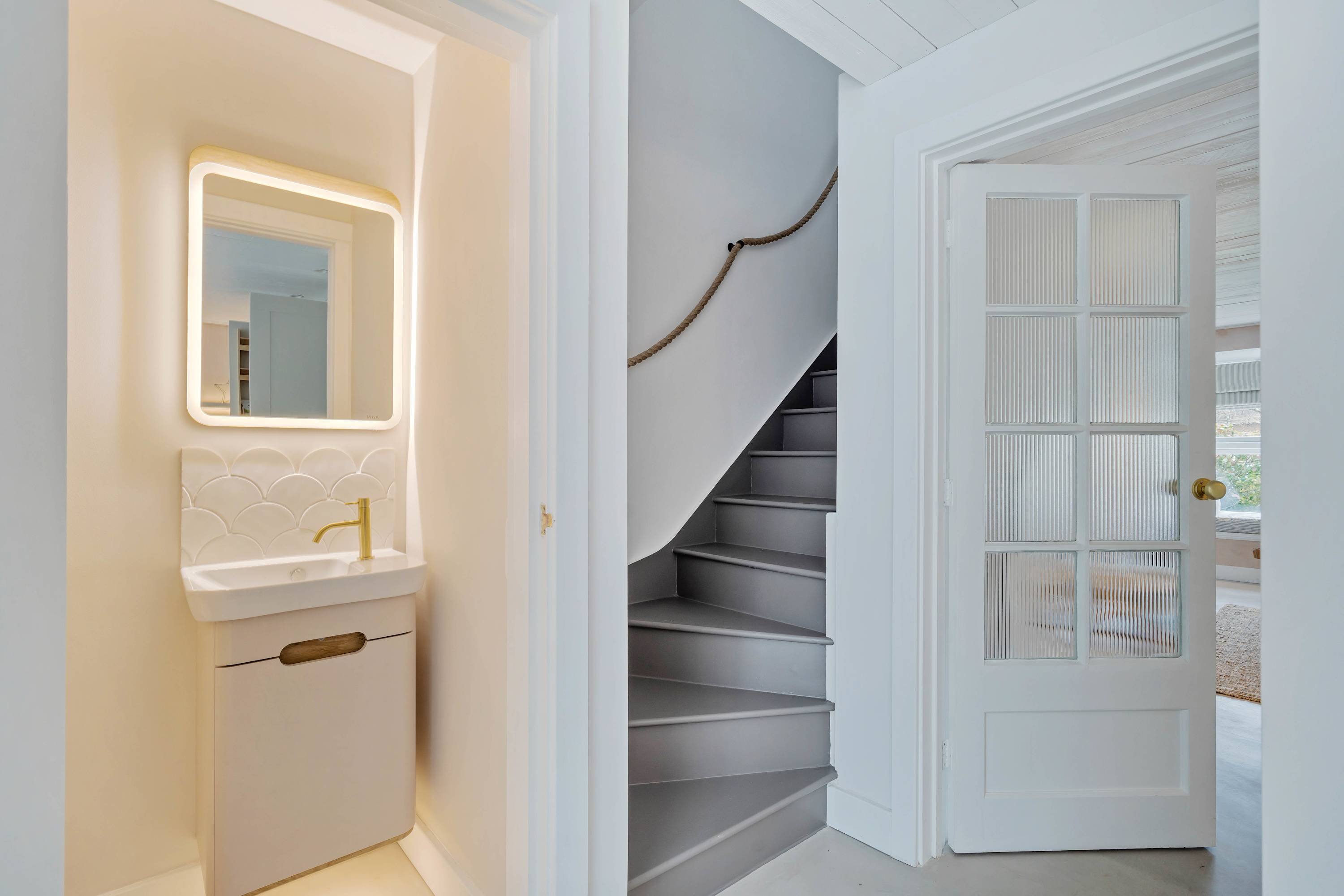 A sleek and minimalistic hallway featuring a handy downstairs cloakroom.