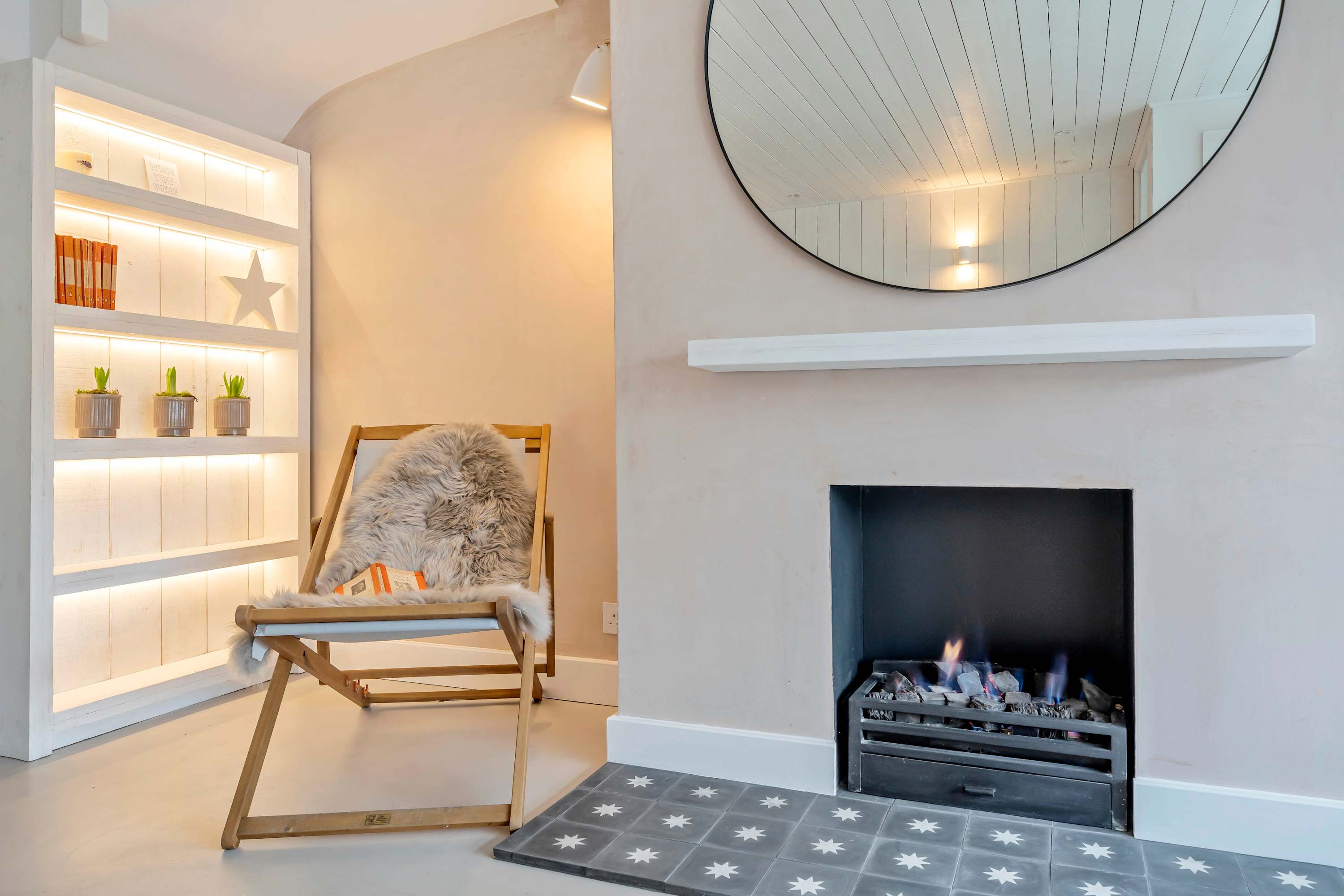 Curl up with a book by the glowing fireplace in this cosy reading nook.