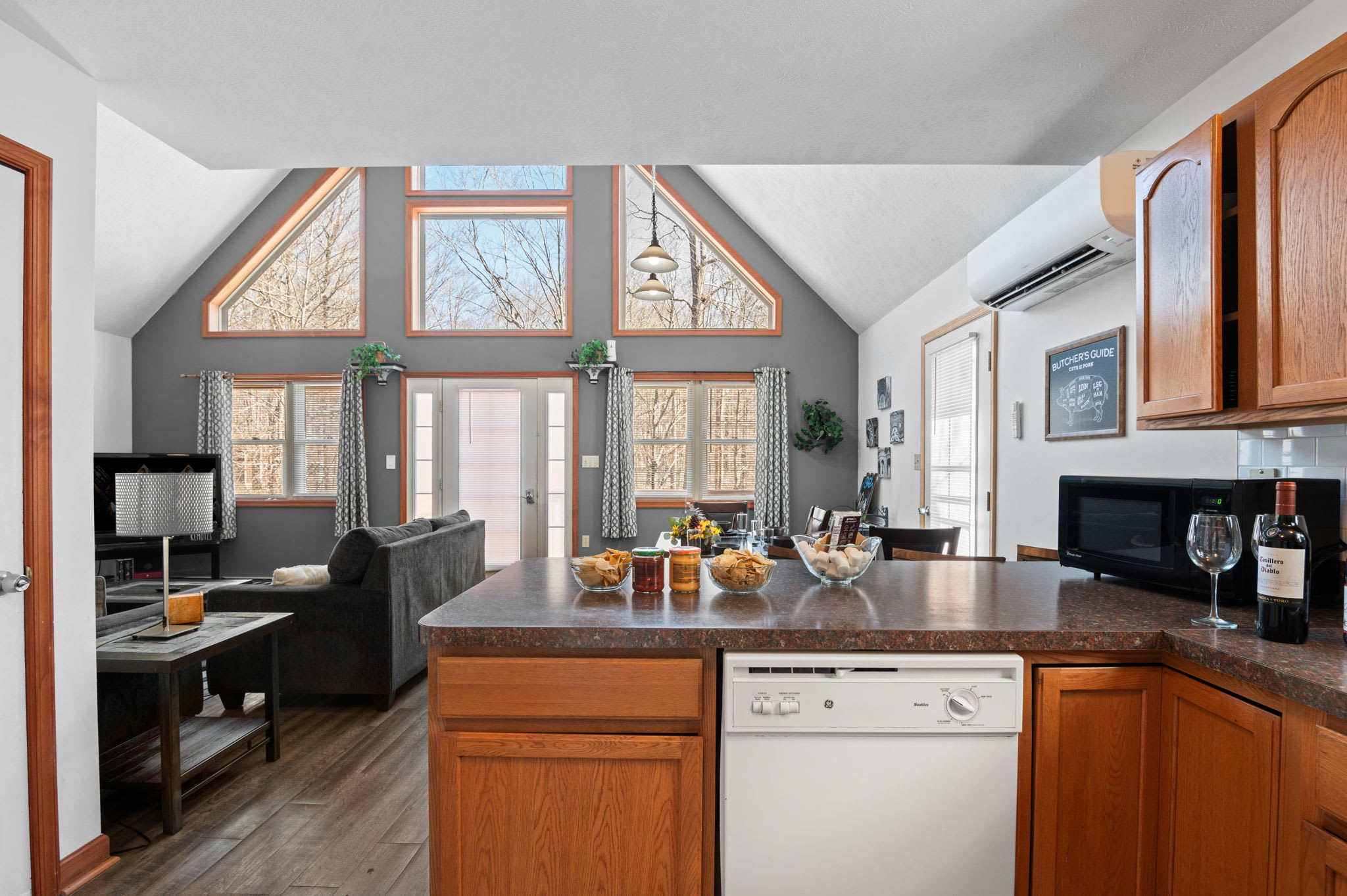 The  kitchen features a bright window overlooking the woods