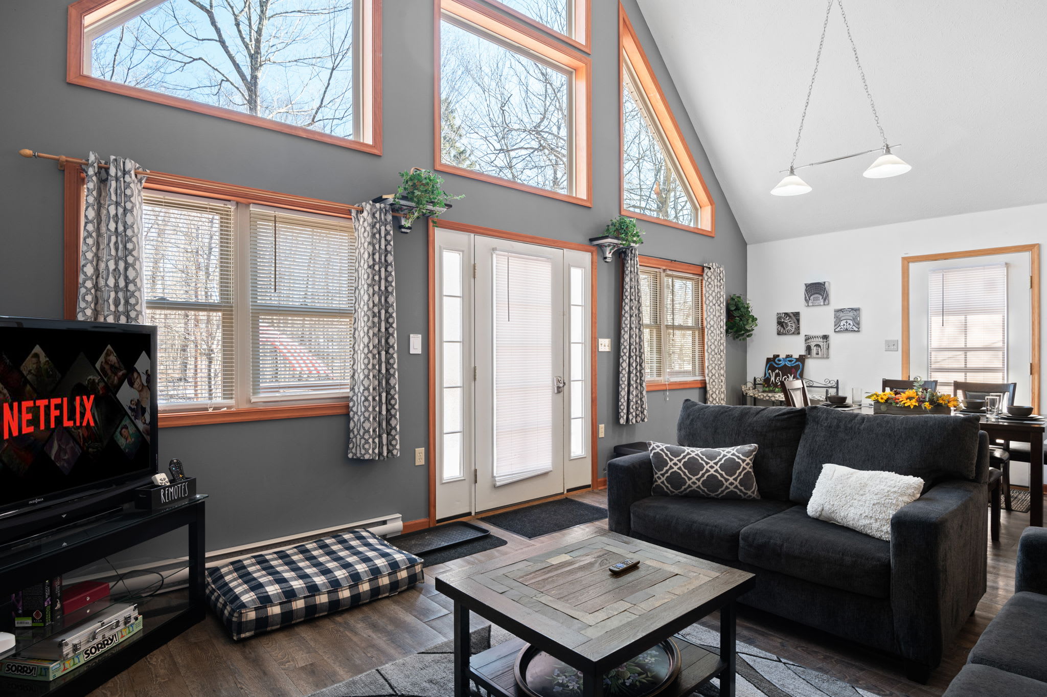 Unwind in the sun-filled living room with soaring A-frame windows and a cozy sofa.