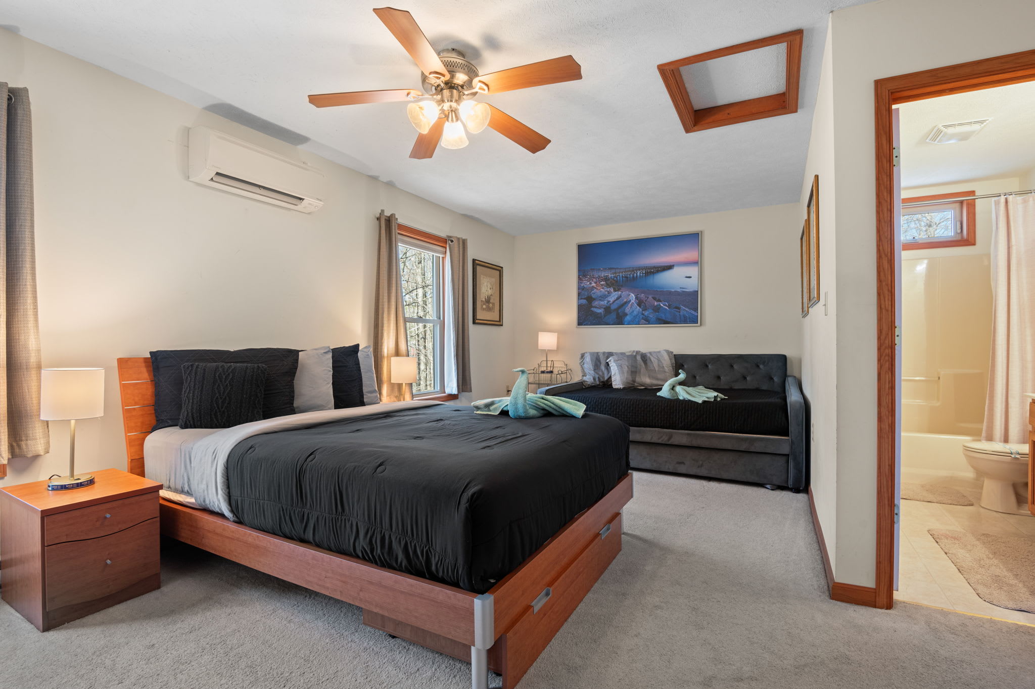 The spacious master bedroom features a comfy queen bed and soothing forest views