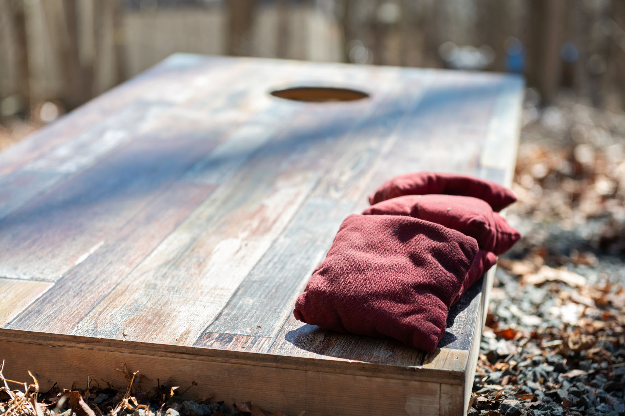 Cornhole boards with bean bags provided for fun outdoor competitions by the fire pit