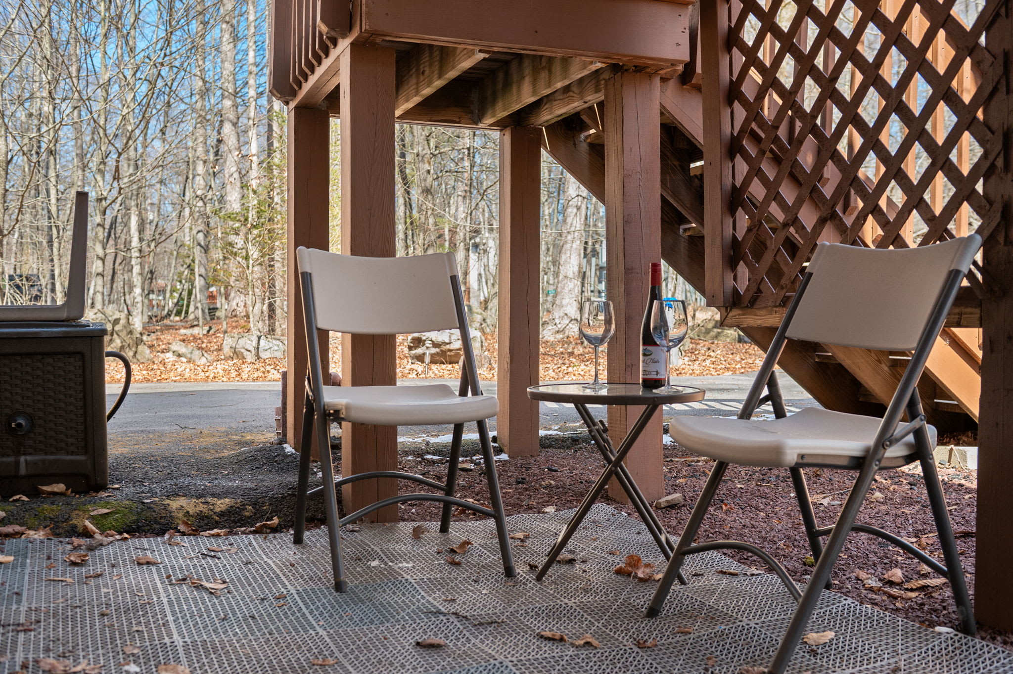 Relax in the covered deck area with comfortable seating overlooking the woods