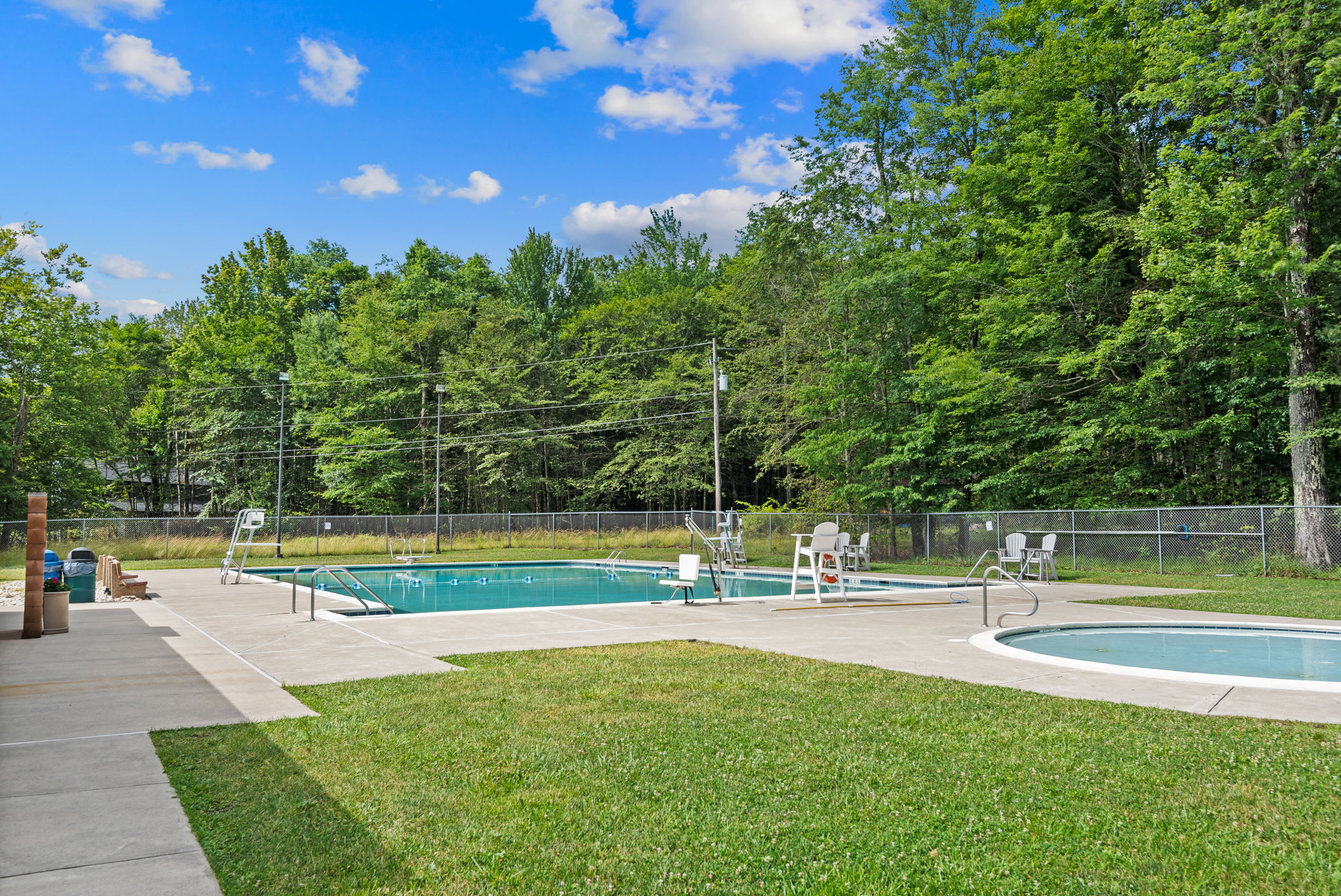 Cool off at the community swimming pool surrounded by lush greenery