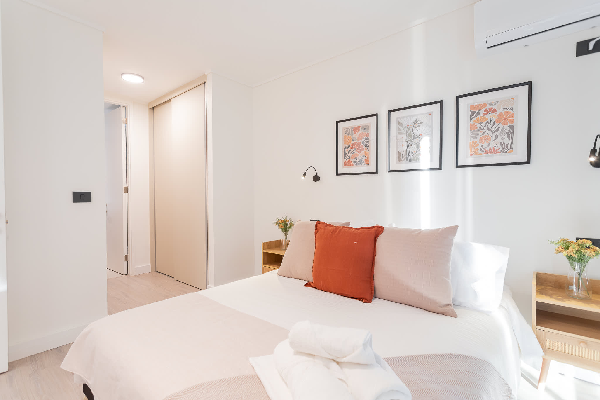 Relax in this cozy, well-lit bedroom featuring stylish decor and a comfortable queen bed, perfect for a restful getaway.