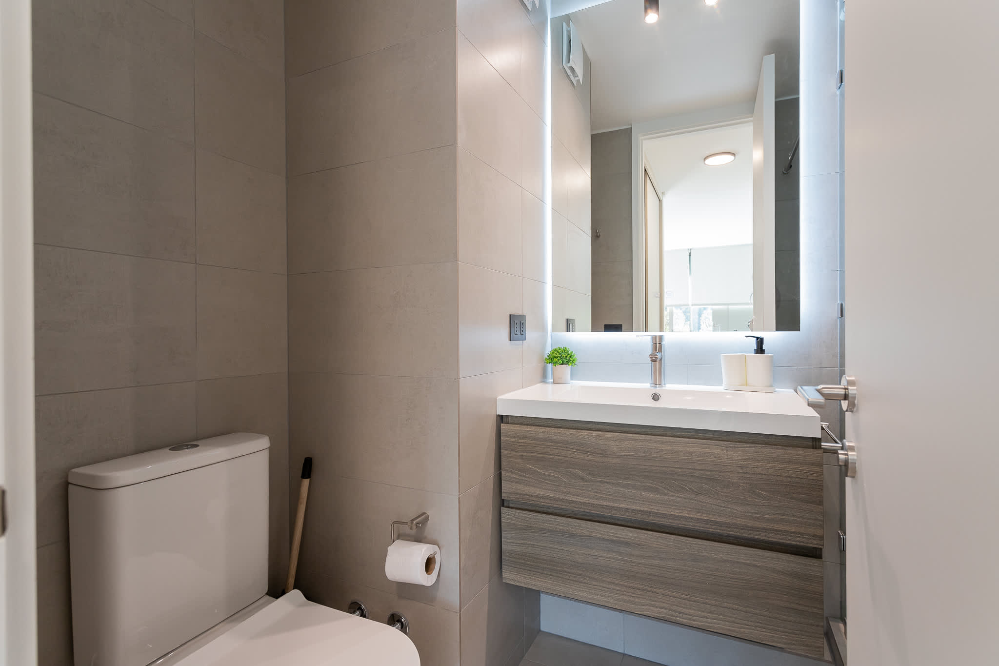Experience a modern bathroom with sleek design and essential amenities for your comfort.