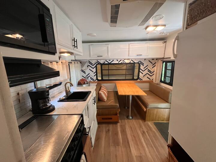 Optional add on camper for additional space/ beds. It is located right next door, a few steps from the front door. It has a very comfortable double bed, a small adult/ child fold down bunk, and the table makes into a bed. Message for details.