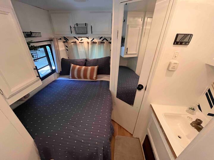 Optional add on camper for additional space/ beds. It is located right next door, a few steps from the front door. It has a very comfortable double bed, a small adult/ child fold down bunk, and the table makes into a bed. Message for details.