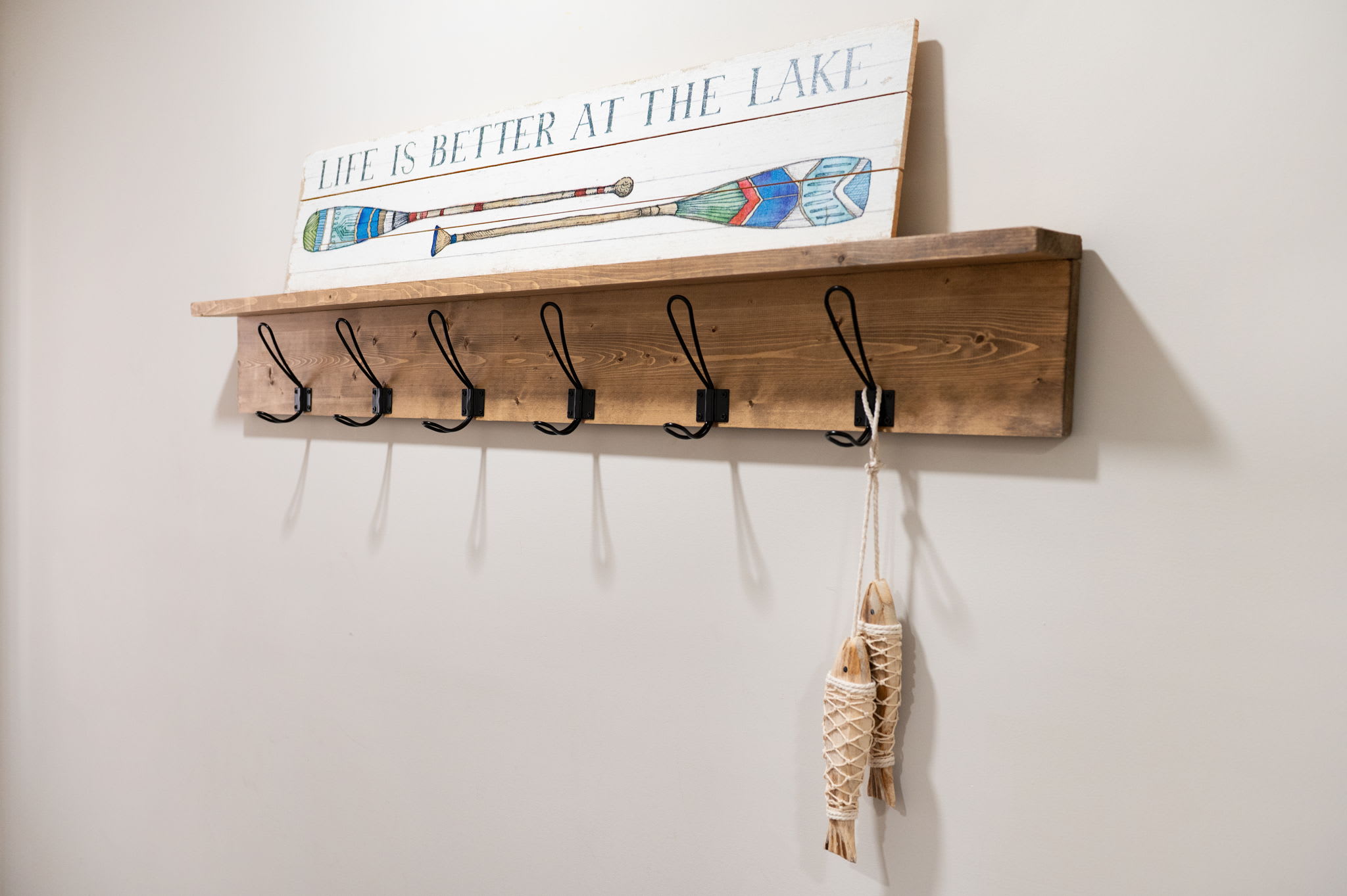 Welcome with a Smile
Charming wall hooks and a lake-inspired sign set the tone for a warm, relaxed stay the second you walk in.