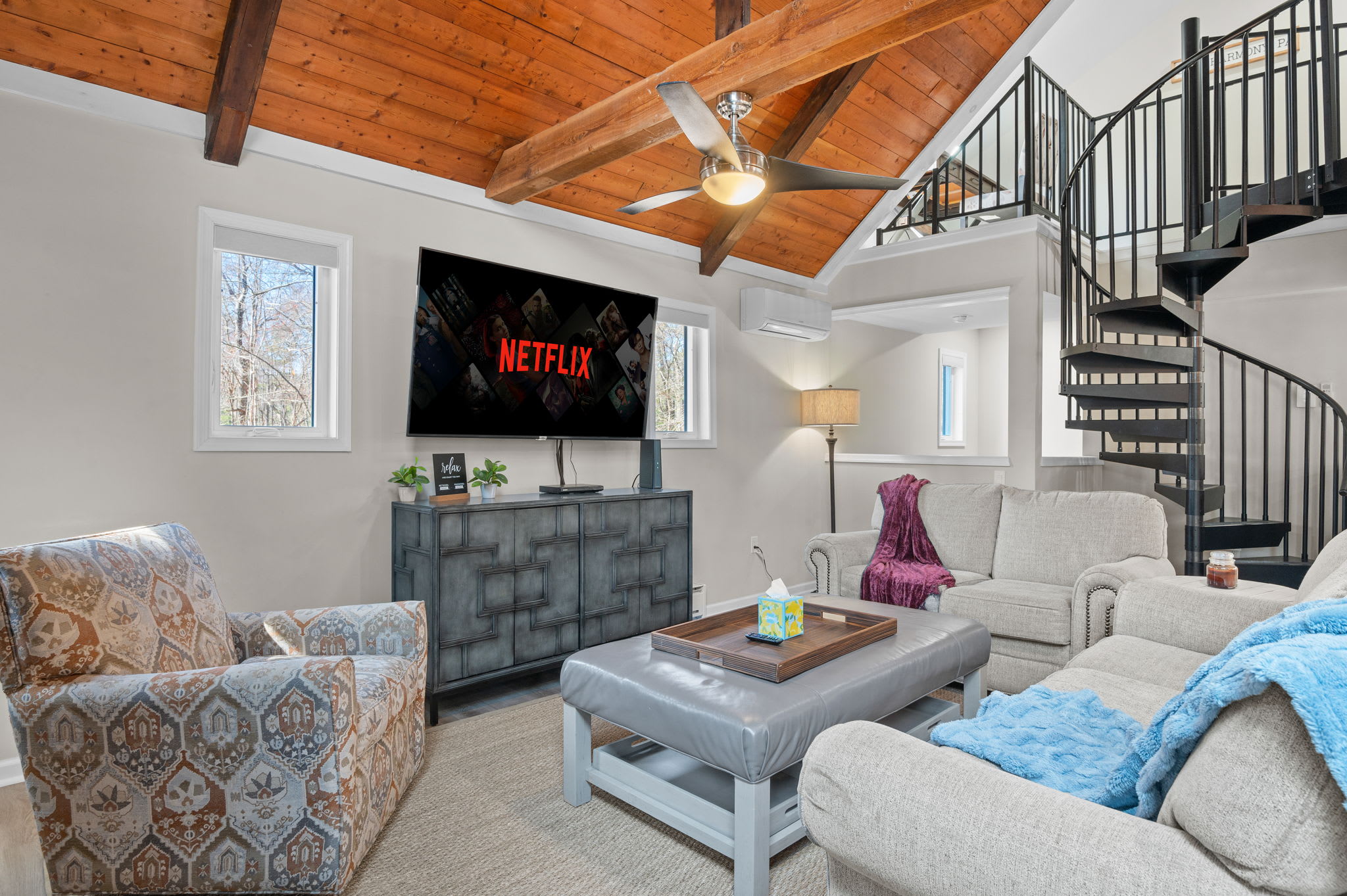 Vaulted Comfort Lounge
High ceilings, plush seating, and a spiral staircase make this space feel both grand and inviting.