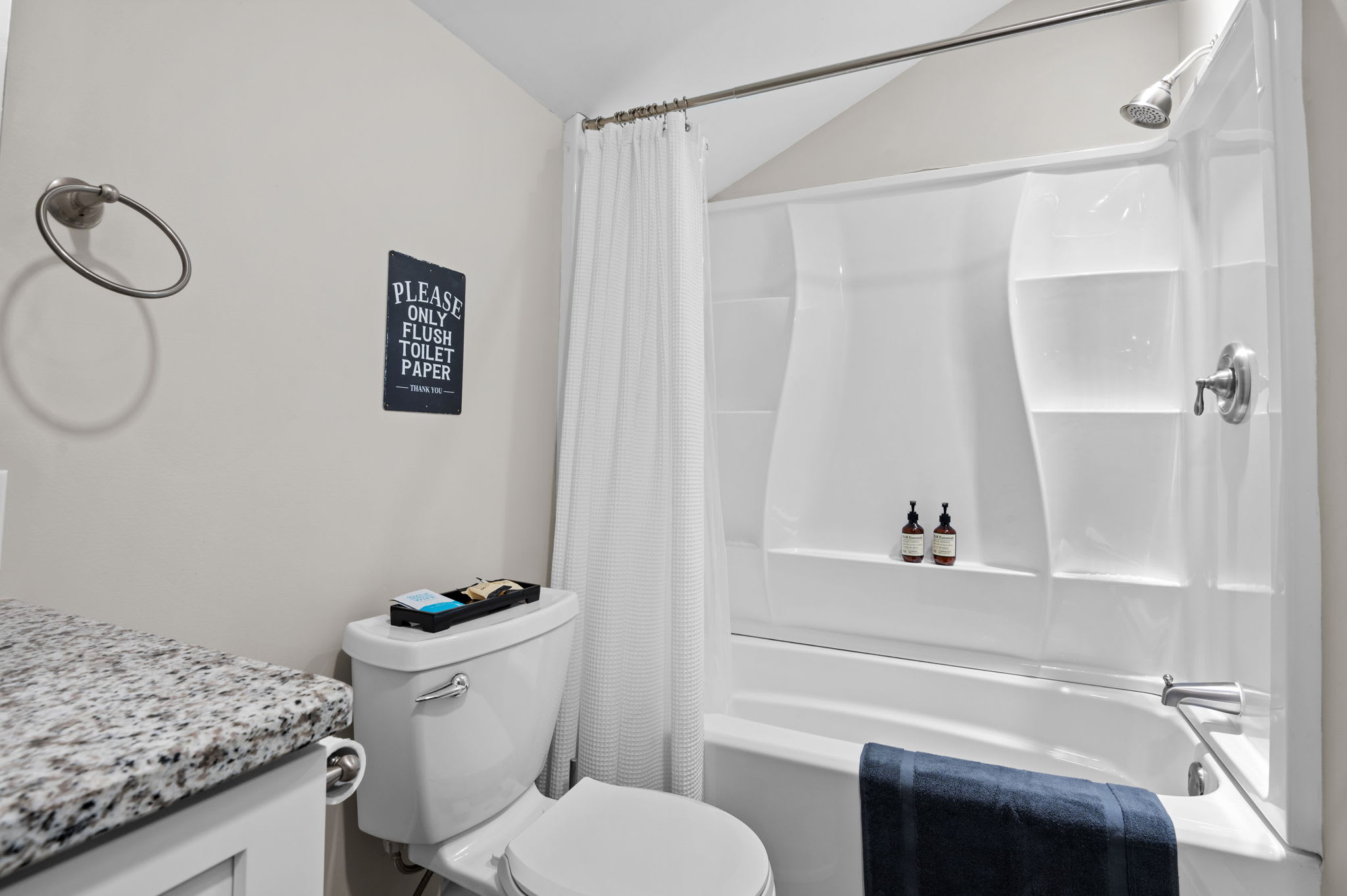 Crisp and Convenient Setup
With a full shower and sleek storage, this bathroom offers comfort and practicality in one tidy space.