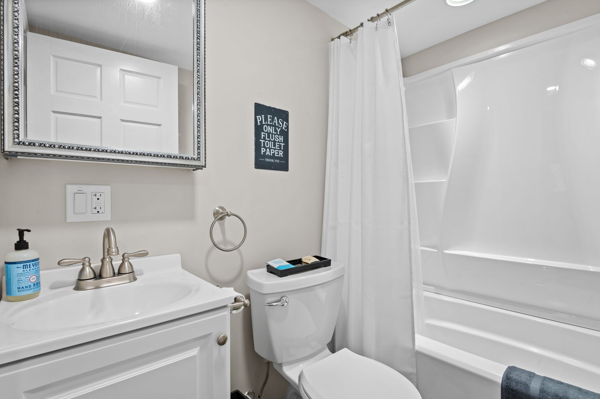 Bright and Tidy Bathroom
A crisp white setup with granite accents and a full shower, offering convenience right off the lounge area.