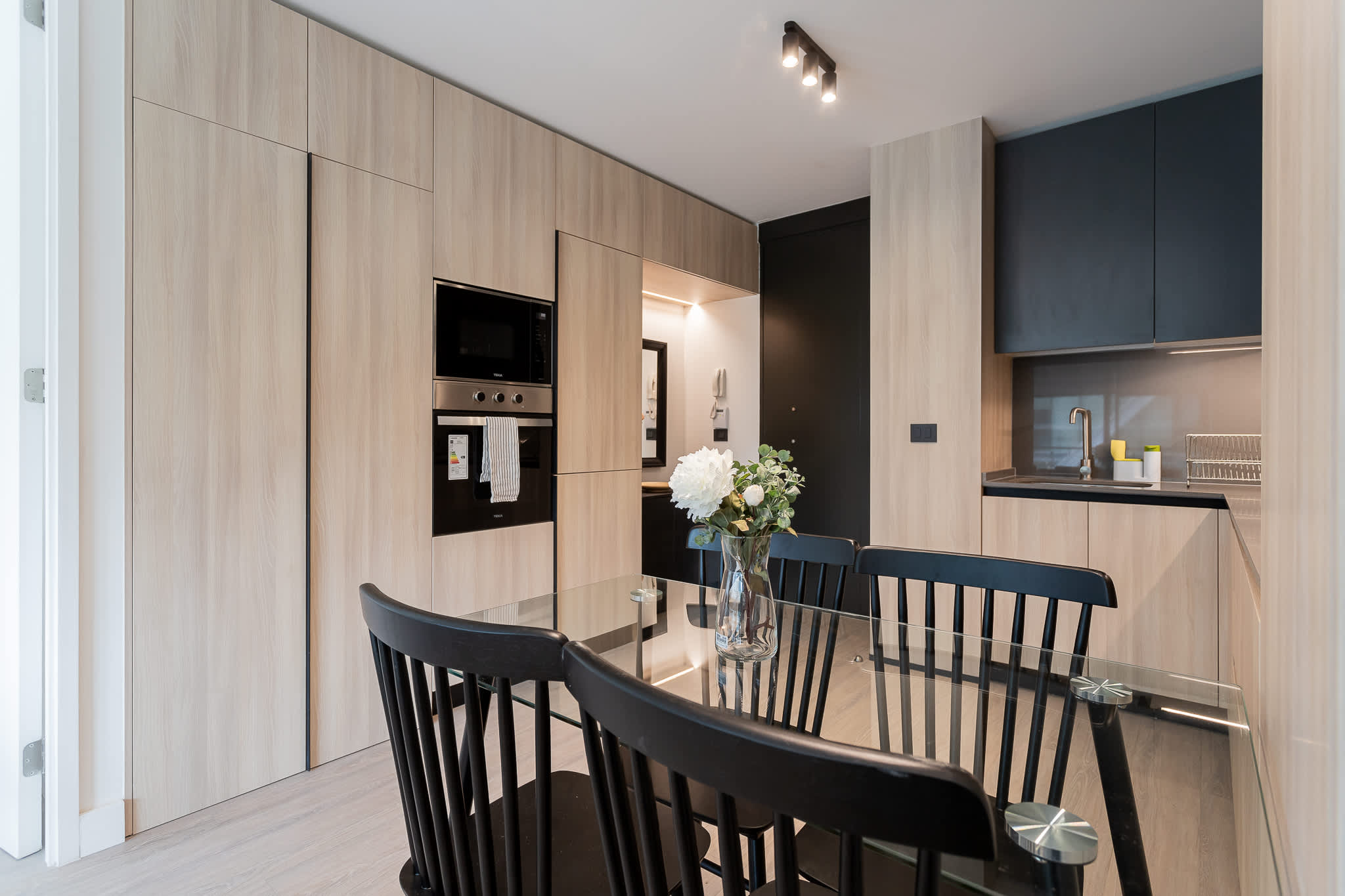 Experience modern living in this sleek kitchen, featuring stylish cabinetry and a cozy dining area perfect for meals and gatherings.