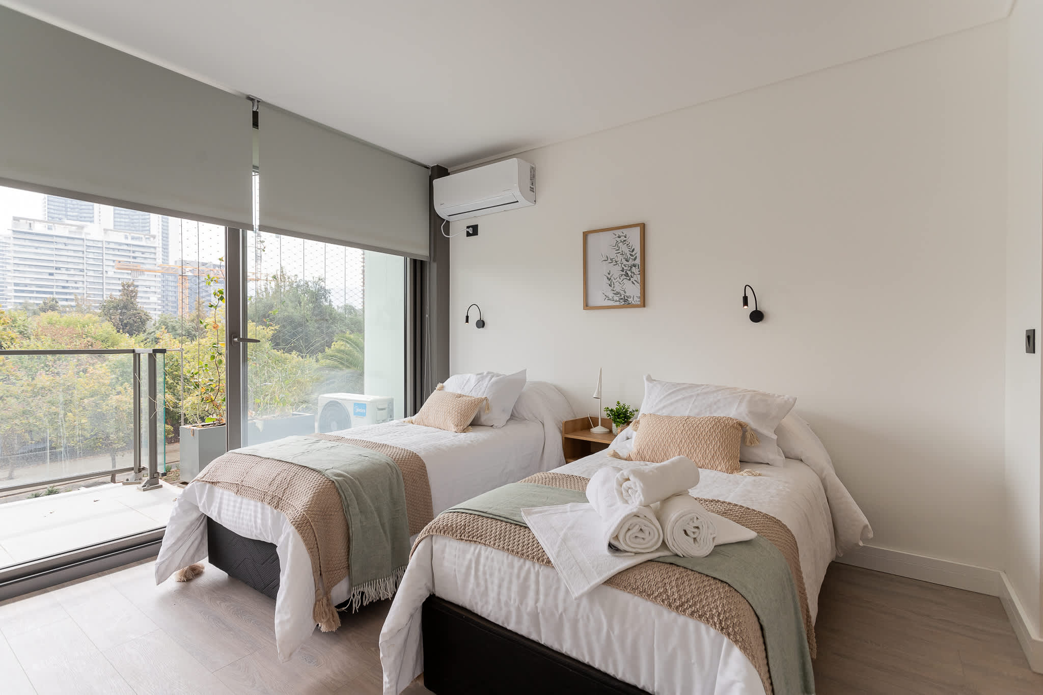 Bright and cozy bedroom with two single beds, perfect for relaxation. Enjoy the view of lush greenery from your window!