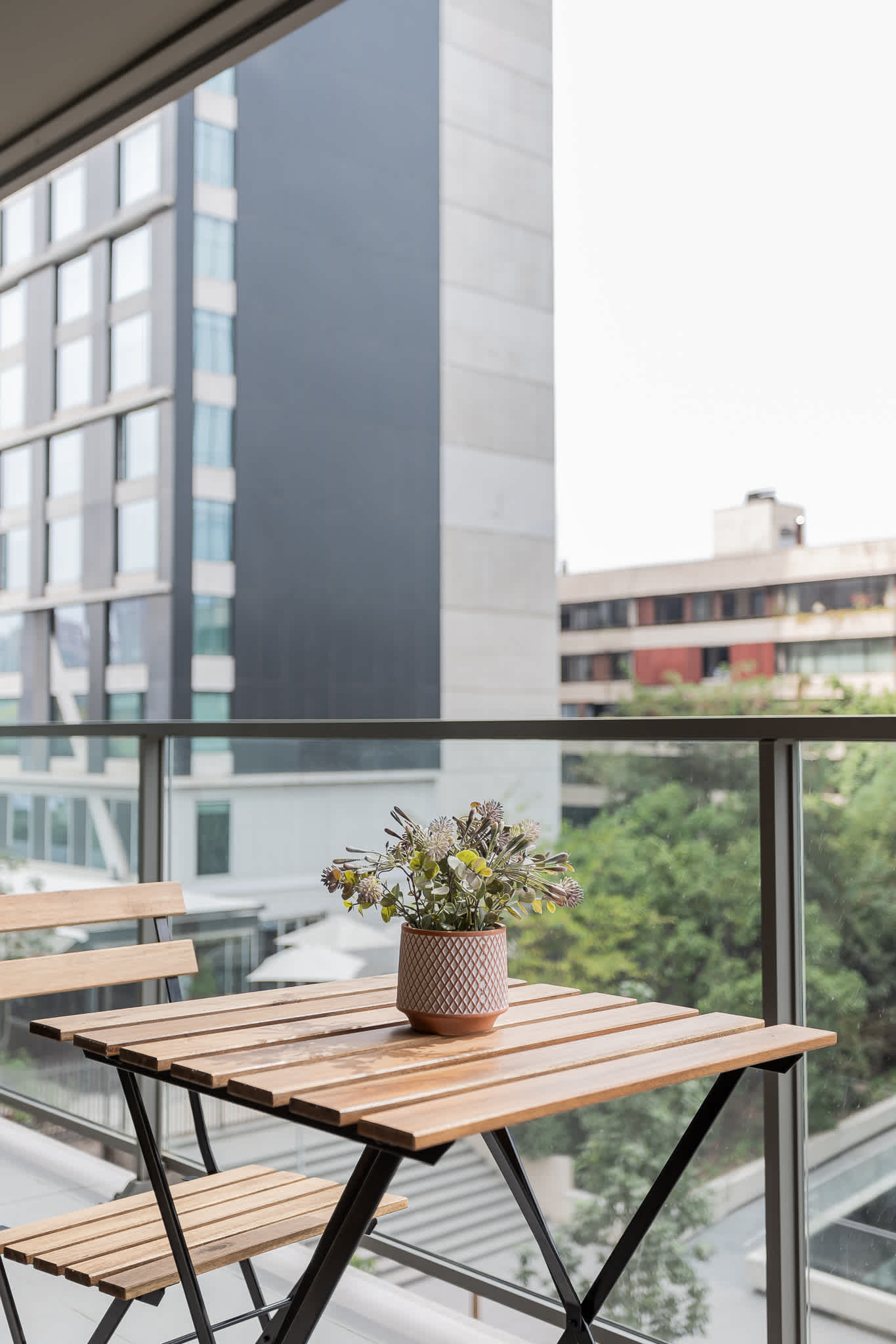 Enjoy a cozy moment on the balcony with a charming view and a touch of greenery.