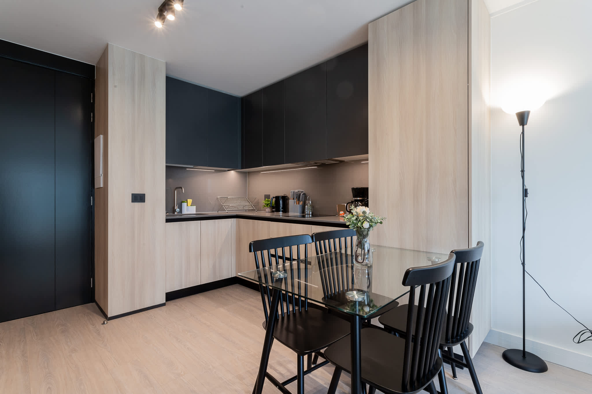 Experience modern living in this stylish kitchen, featuring sleek cabinetry and a cozy dining area perfect for meals and gatherings.