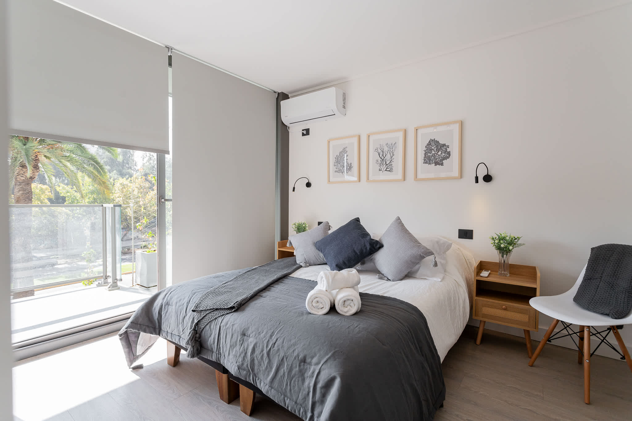 Relax in this serene bedroom with balcony access, perfect for unwinding with a view of lush greenery.