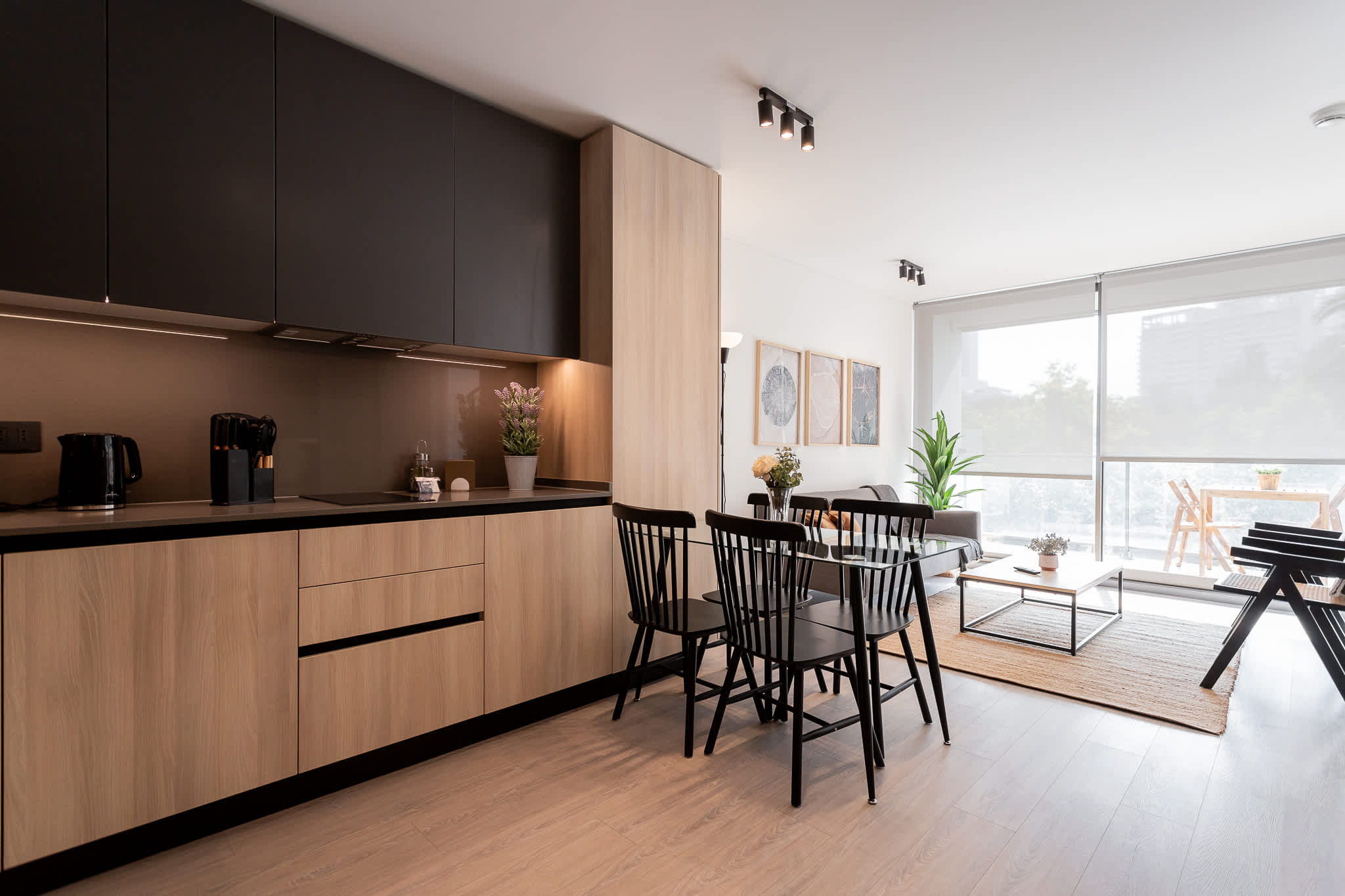 Savor meals in this chic kitchen and dining area, bathed in natural light with modern decor and a cozy vibe.