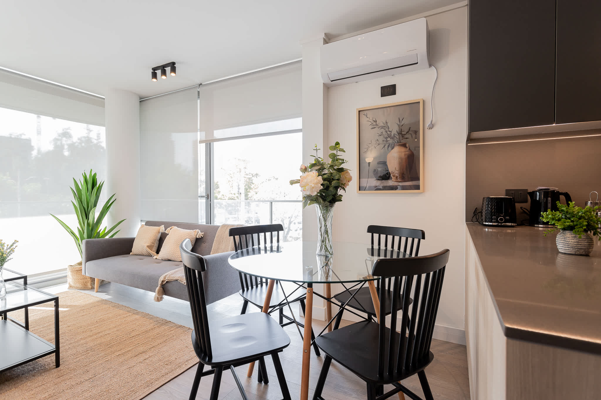 Bright and modern living space with chic decor and ample natural light, perfect for relaxation and dining.