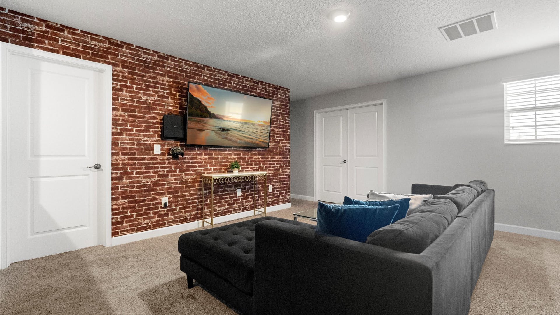 Upstairs TV Lounge with Industrial-style brick wall and large smart TV