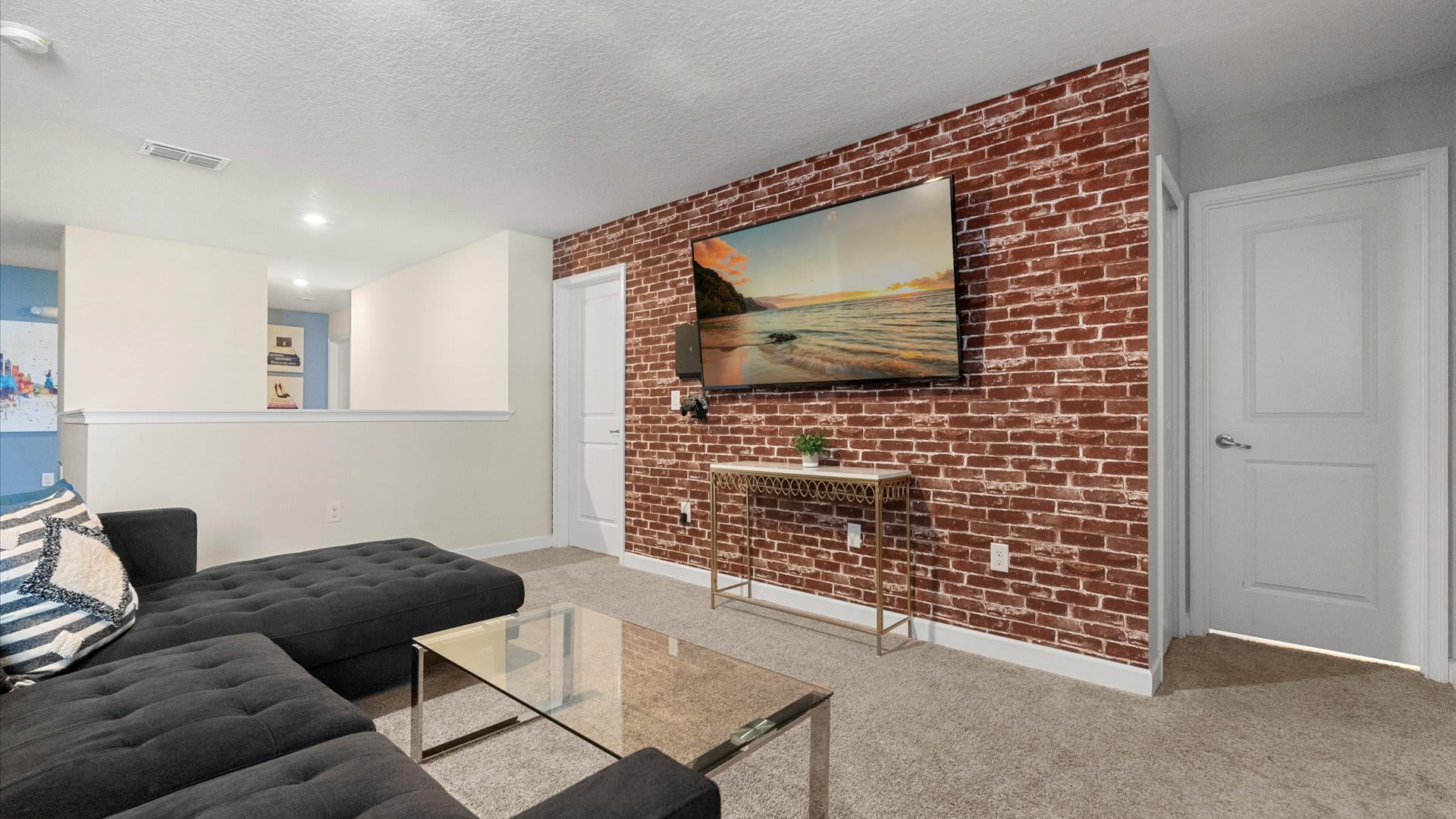 Upstairs TV Lounge with Industrial-style brick wall and large smart TV