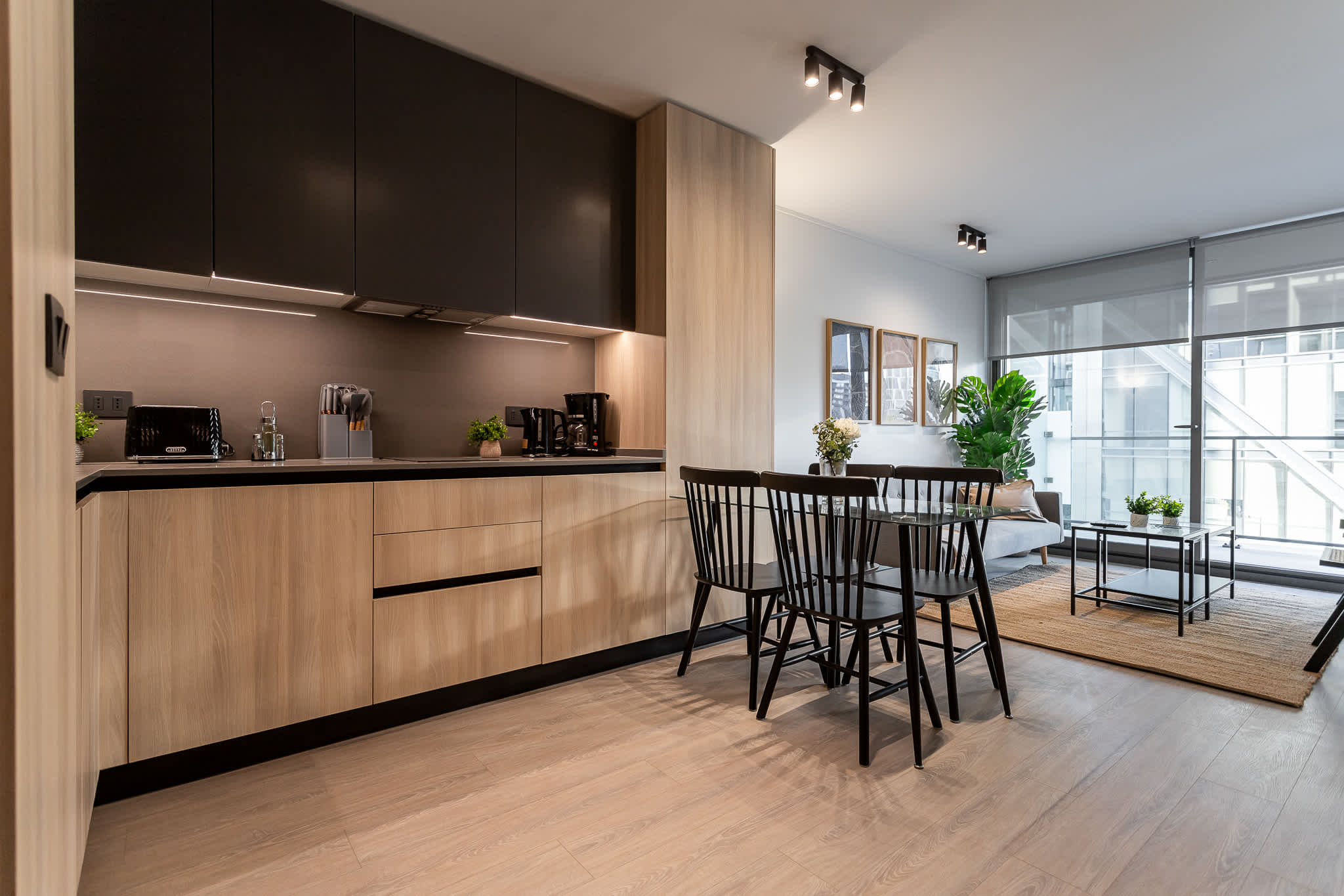 Experience modern living in this stylish kitchen, featuring sleek cabinetry and a cozy dining area bathed in natural light.