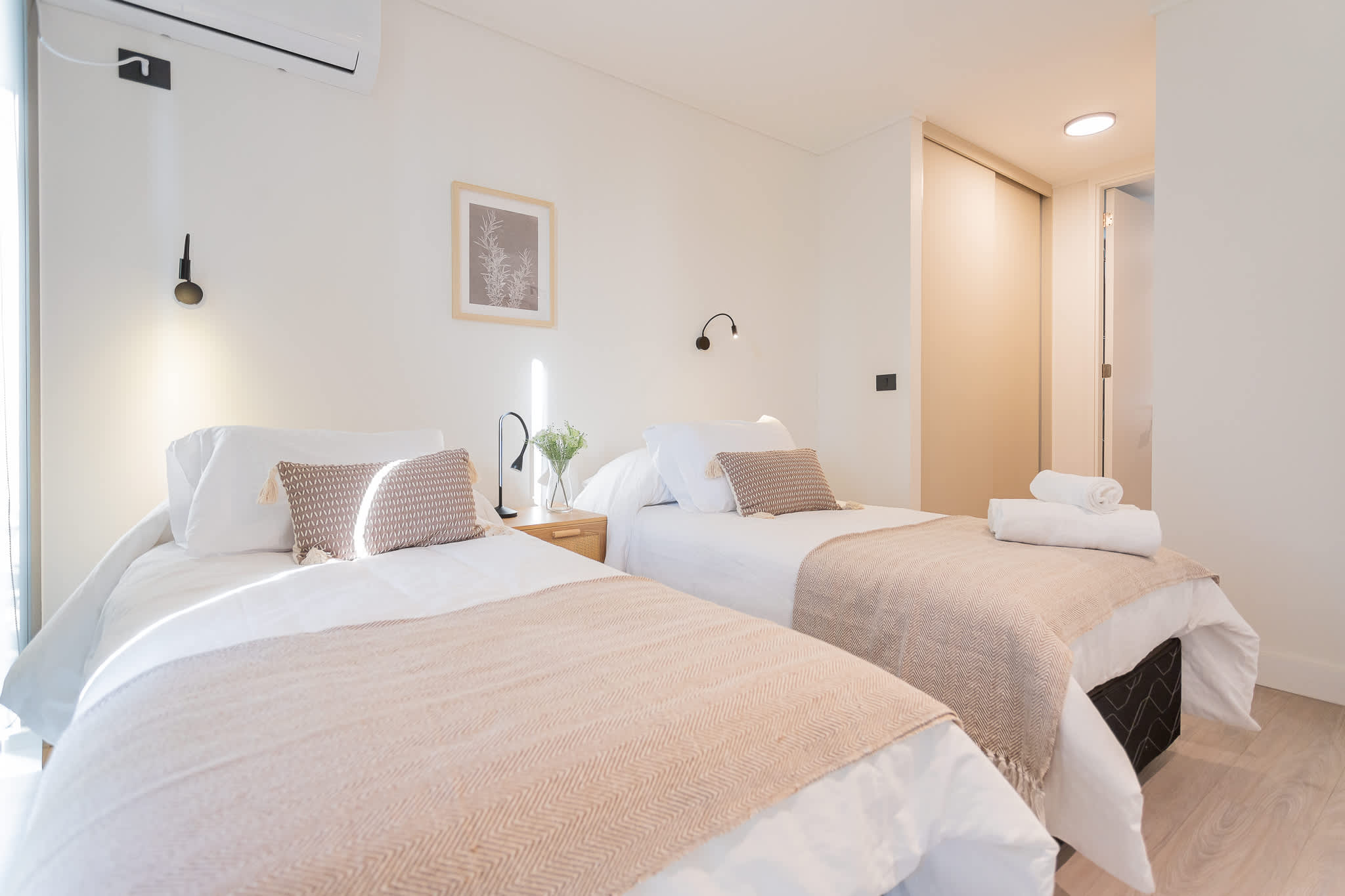 Relax in this modern bedroom featuring two cozy beds, stylish decor, and a serene atmosphere perfect for unwinding after a day of adventure.