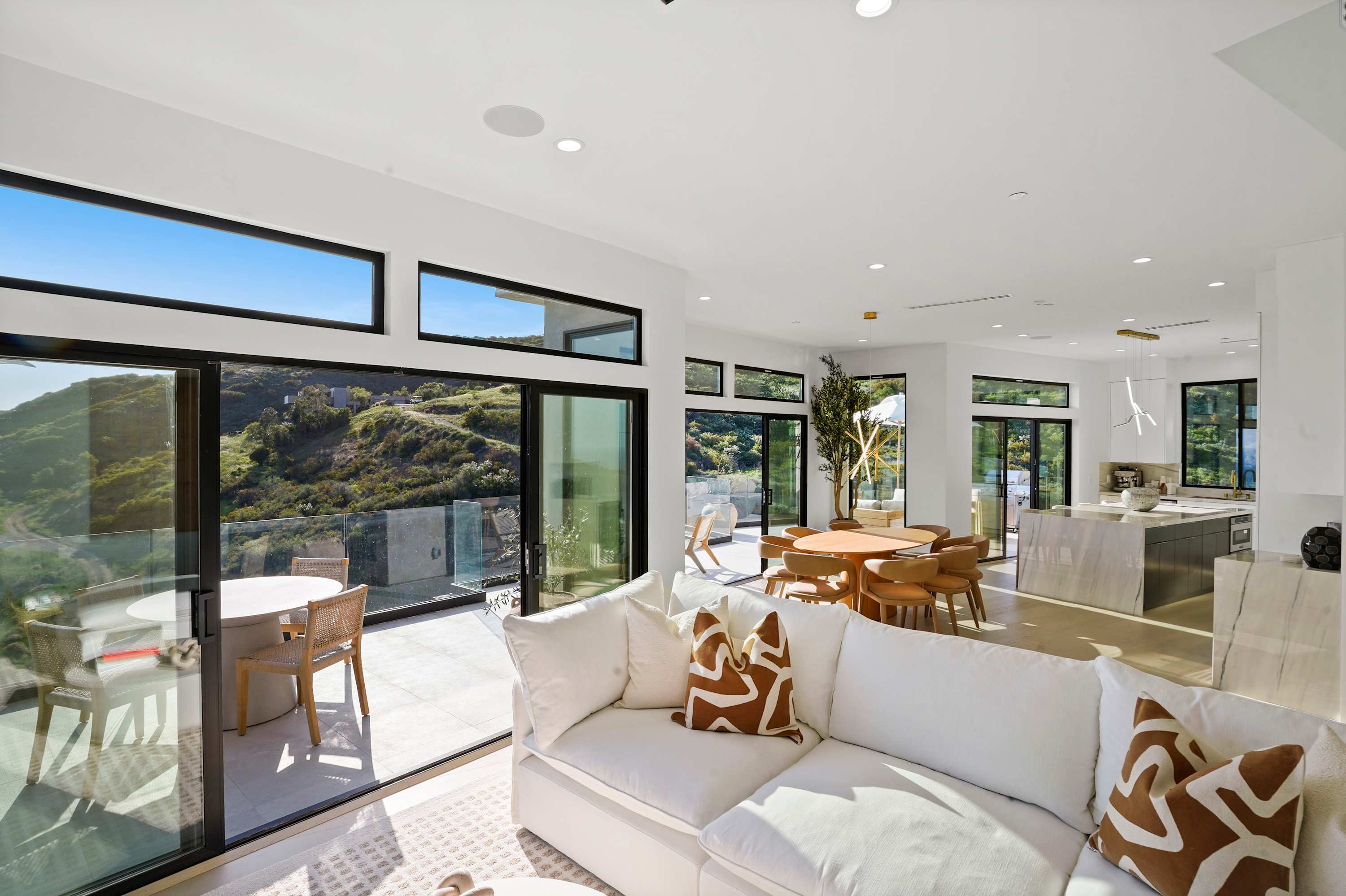 Seamless indoor-outdoor living with hillside and stunning views at every turn.