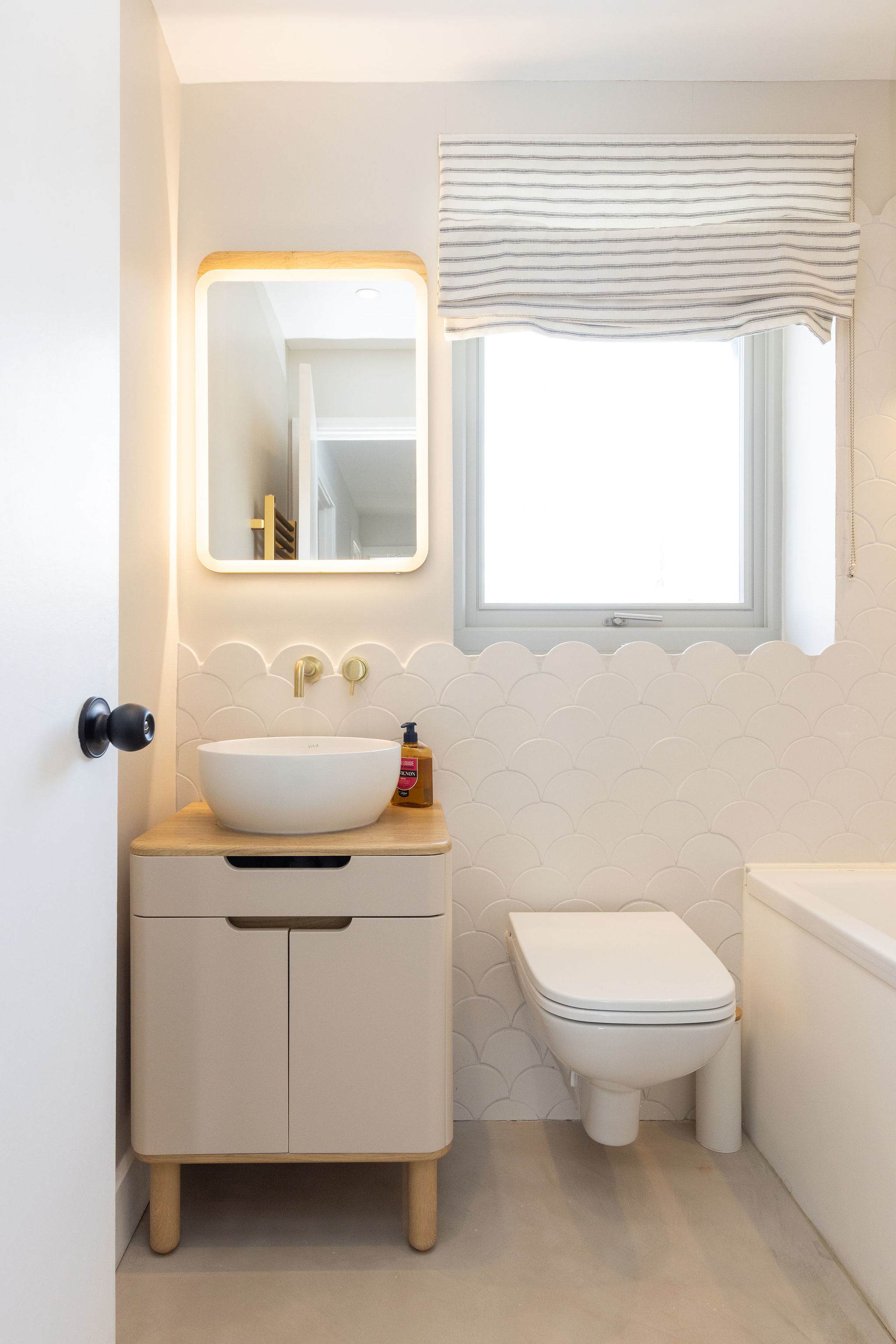 The bathroom is beautifully fitted out with mermaid tiles and gold fixtures.