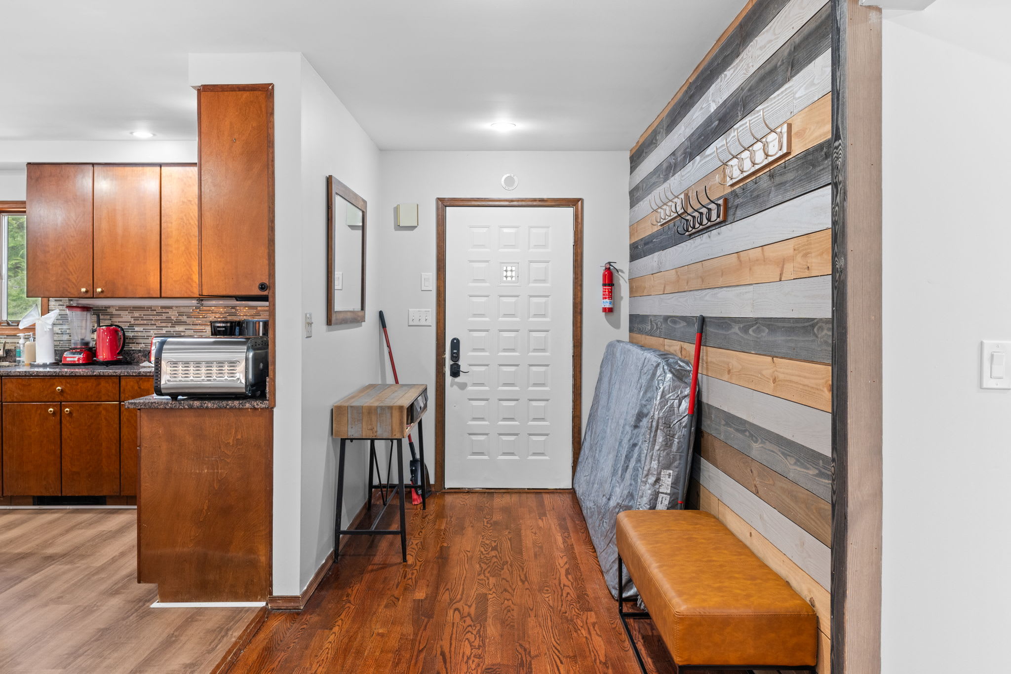 Warm Entryway Vibes
A rustic accent wall and bench create the perfect spot to kick off your shoes and settle in.