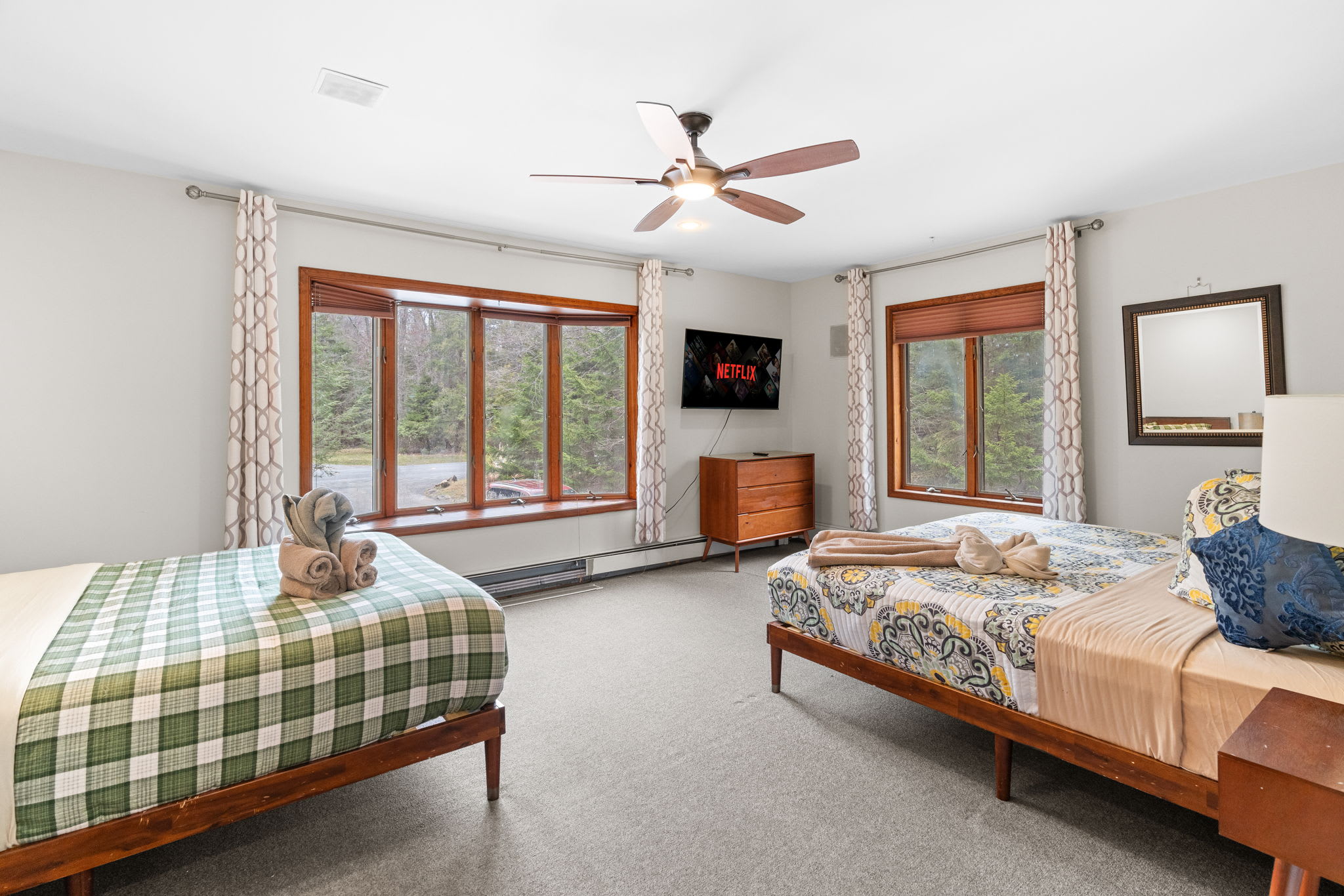 Spacious and Sunny Retreat
A roomy bedroom with large windows and a ceiling fan, made for restful sleep and laid-back mornings.