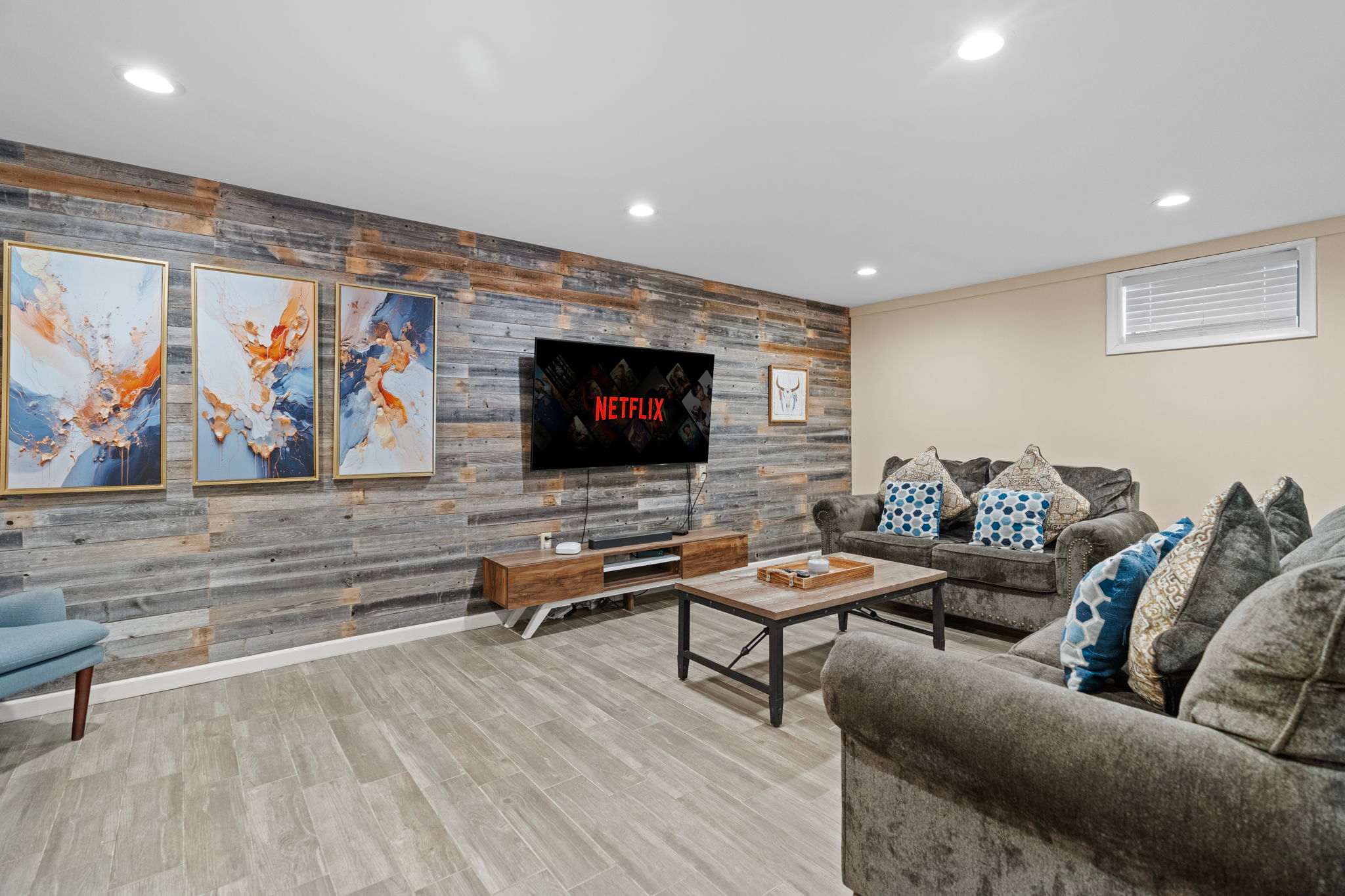 Movie Night Headquarters
A massive TV, cozy couches, and rustic wall accents create the ultimate chill zone for binge-watching or game day.