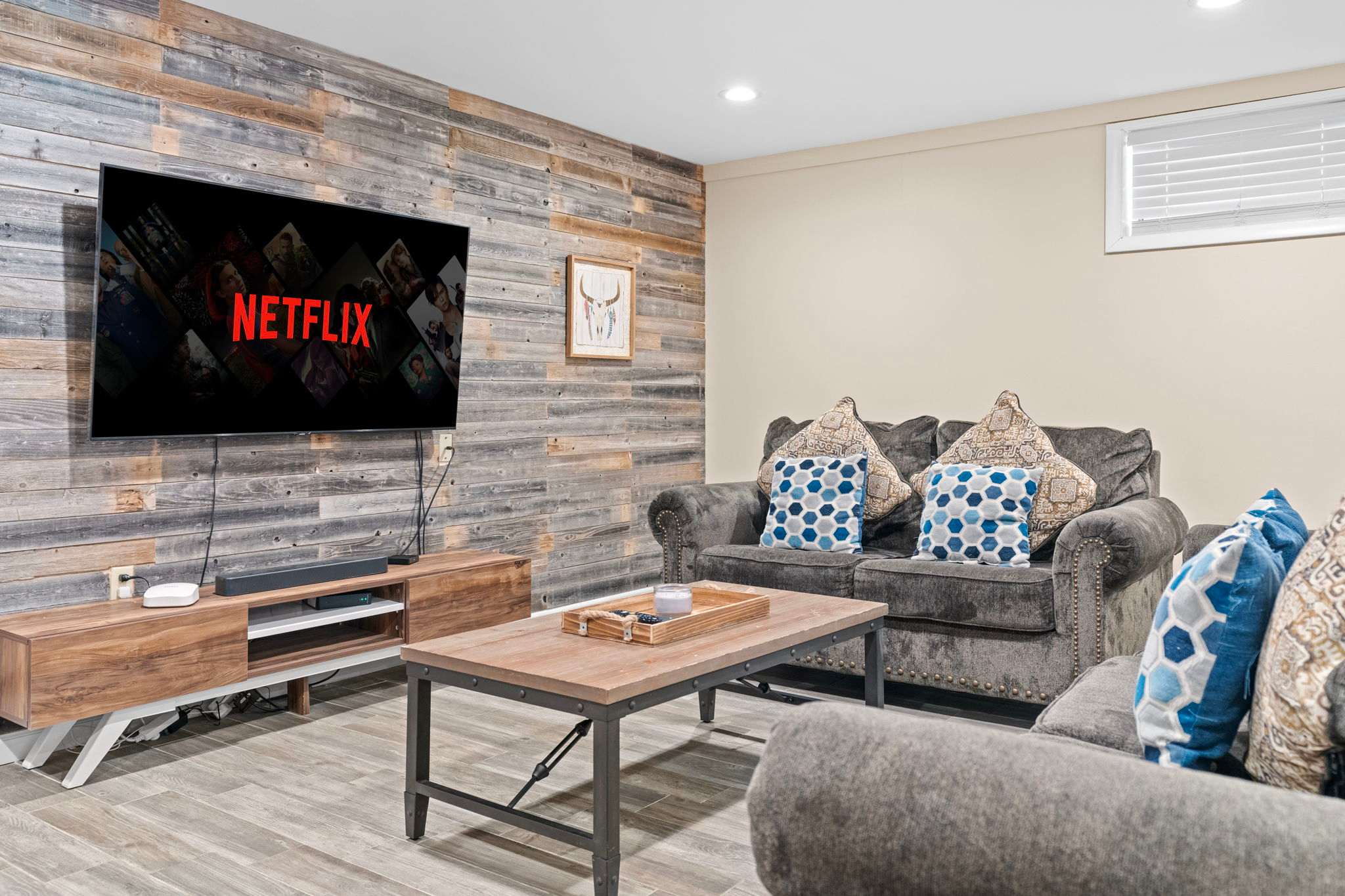 Rustic Wall, Modern Comfort
A warm wood backdrop and plush seating bring together cozy charm and entertainment ease.