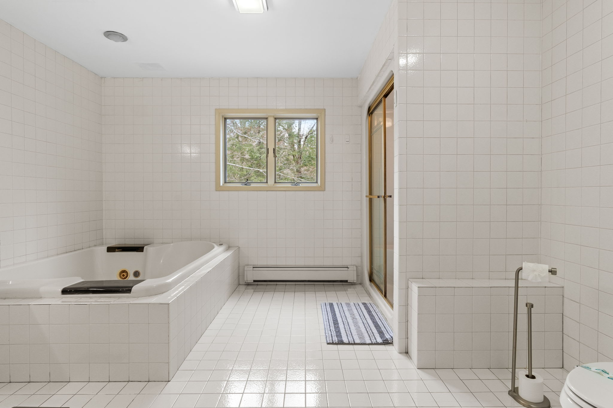 Spacious Spa-Style Bath
Unwind in this large, tiled bathroom featuring a deep soaking tub and plenty of space to spread out.