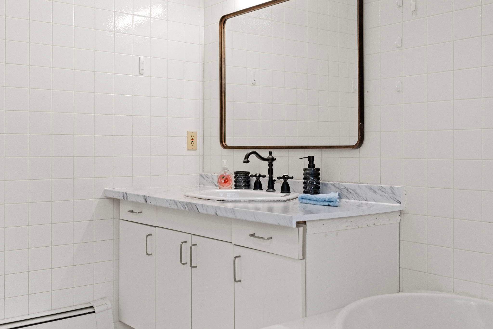 Simple and Sleek Setup
Clean white tiles and warm wood accents keep this bathroom feeling fresh and functional.