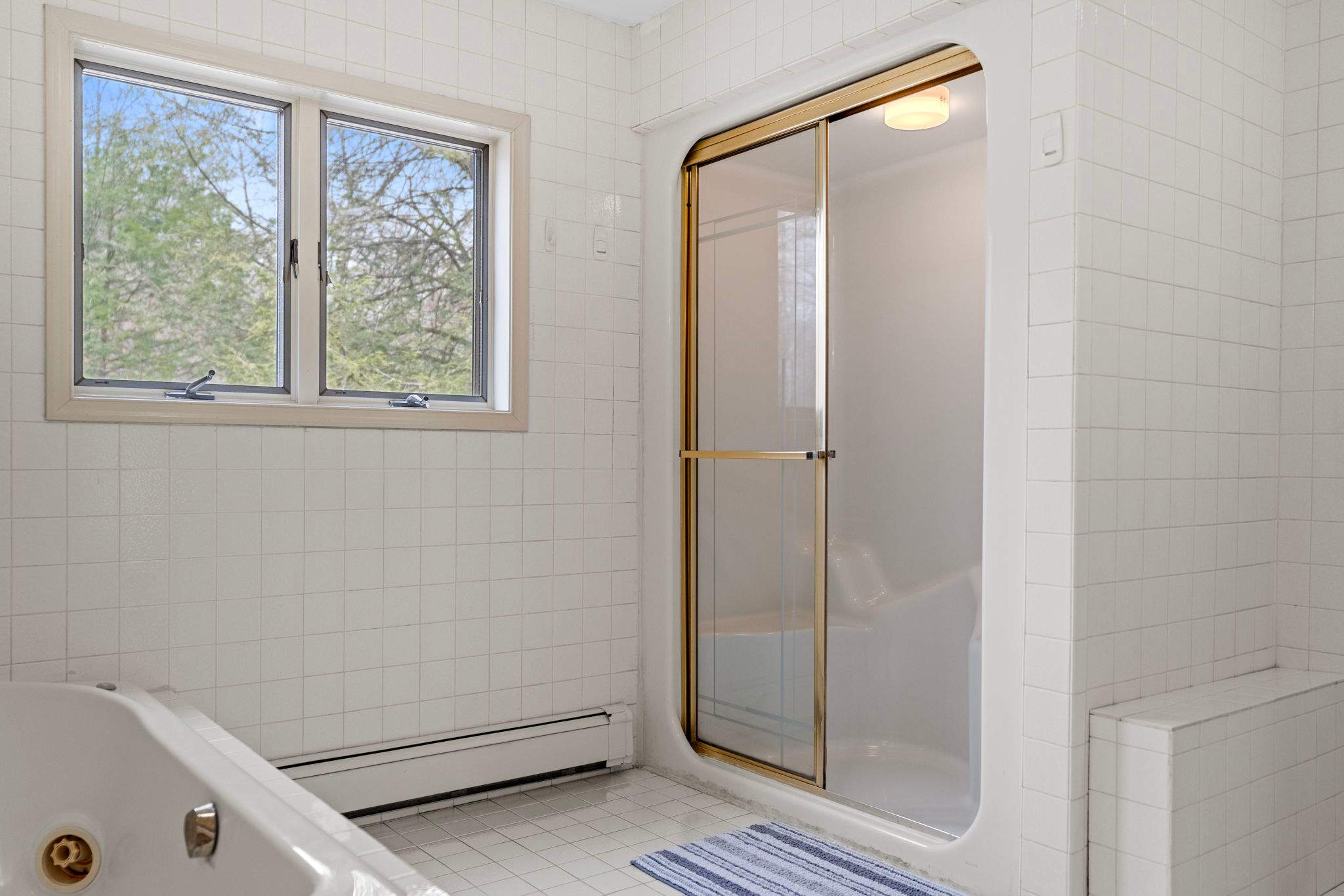 Walk-In Shower Convenience
Step into a bright and spacious shower with glass doors and natural light pouring in.