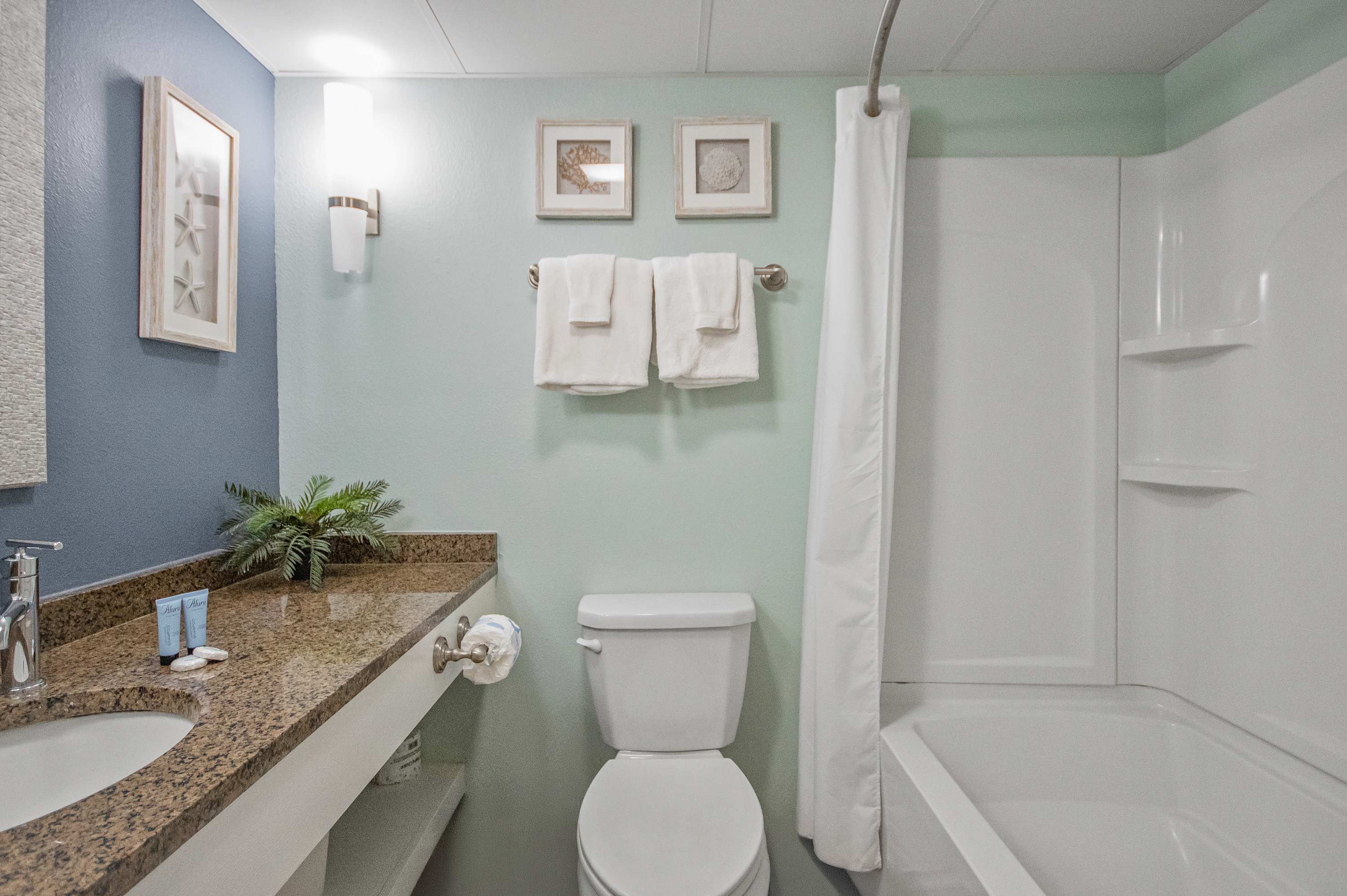 Refresh in a sparkling clean bathroom with fluffy towels and bright lighting.