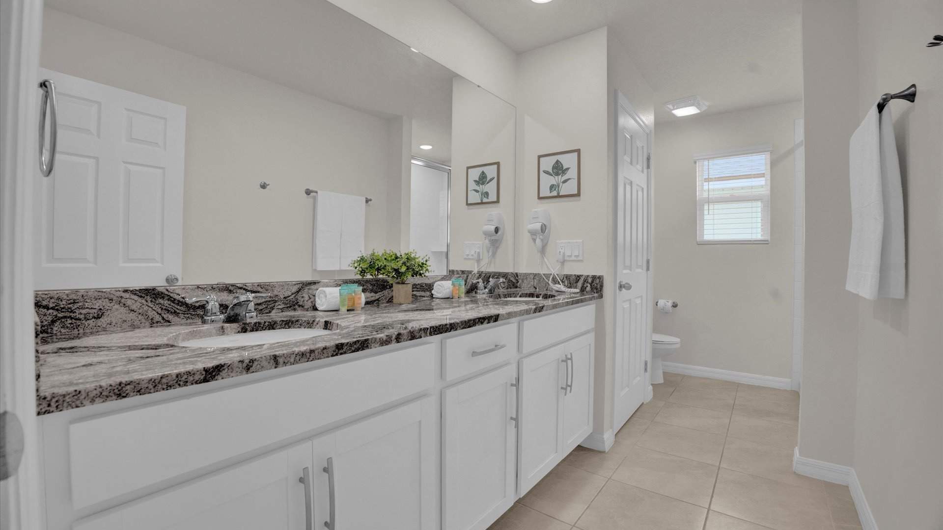 Spacious bathroom with double vanity, fresh towels and complimentary toiletries