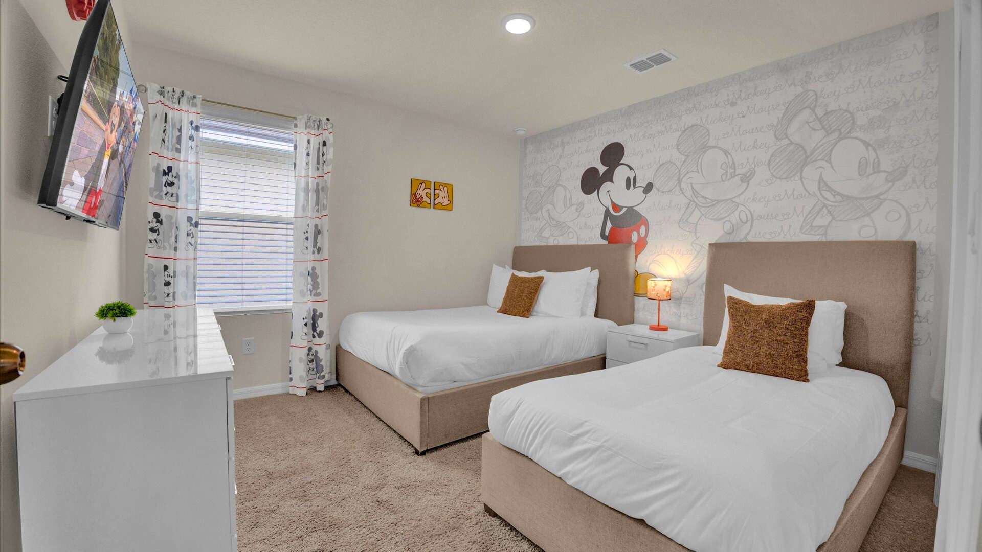 Mickey-moused themed bedroom with a full and single bed a smart TV