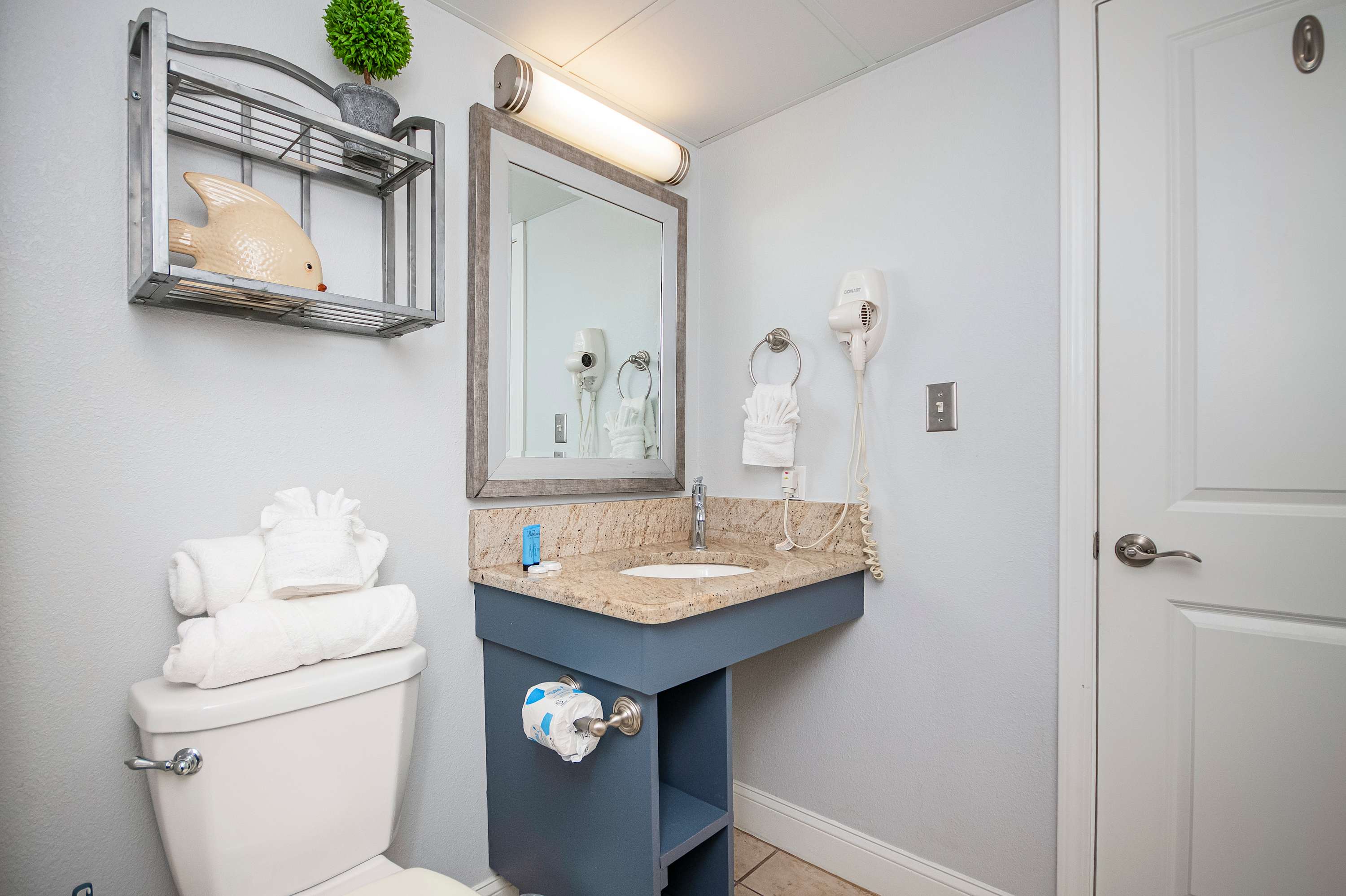 Bright vanity lighting and a spacious shower await your arrival.